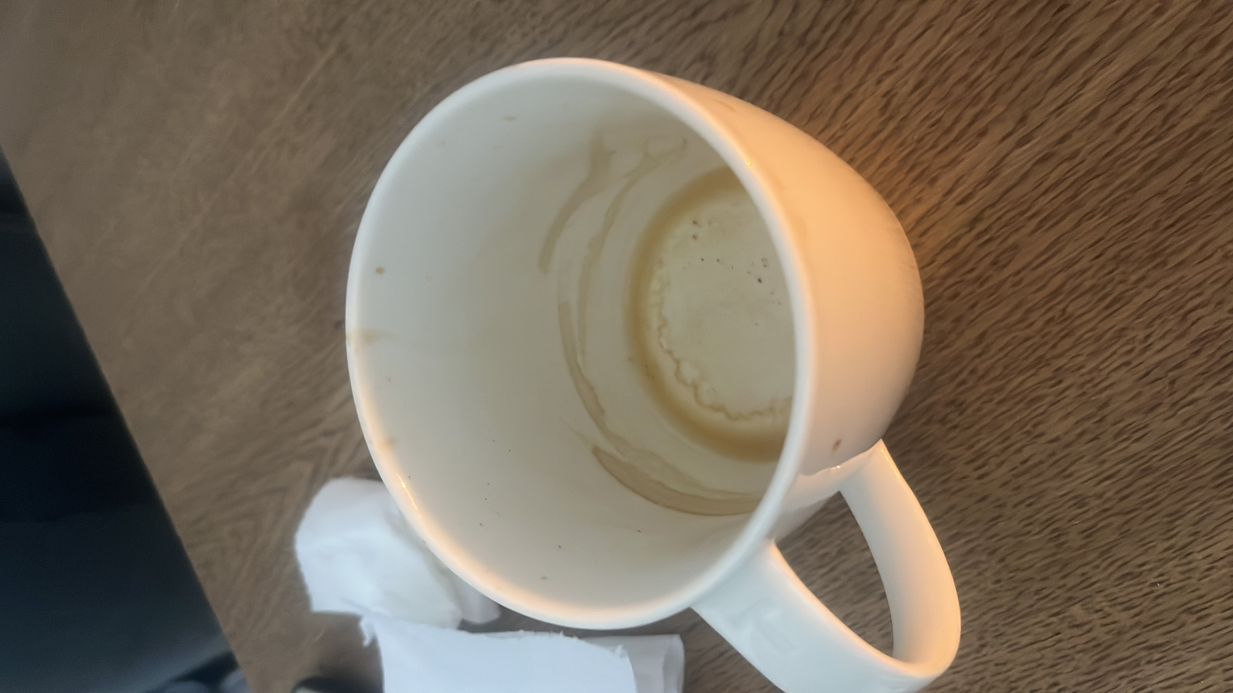 The image shows an empty cup with coffee residue, indicating that the beverage consumed was likely coffee or a similar drink.