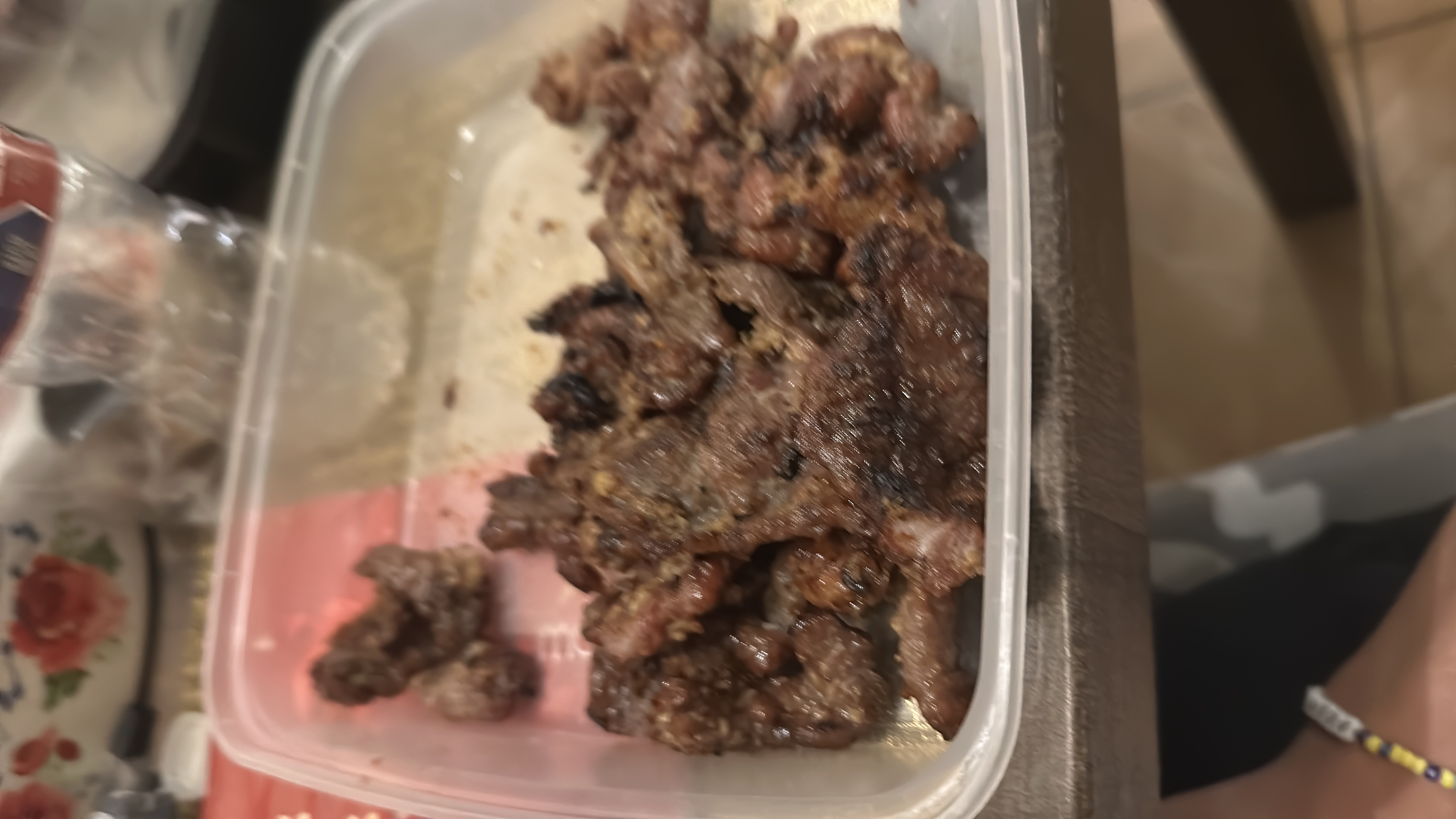 The image shows a container of grilled pork, which is high in protein and fats with minimal carbohydrates.