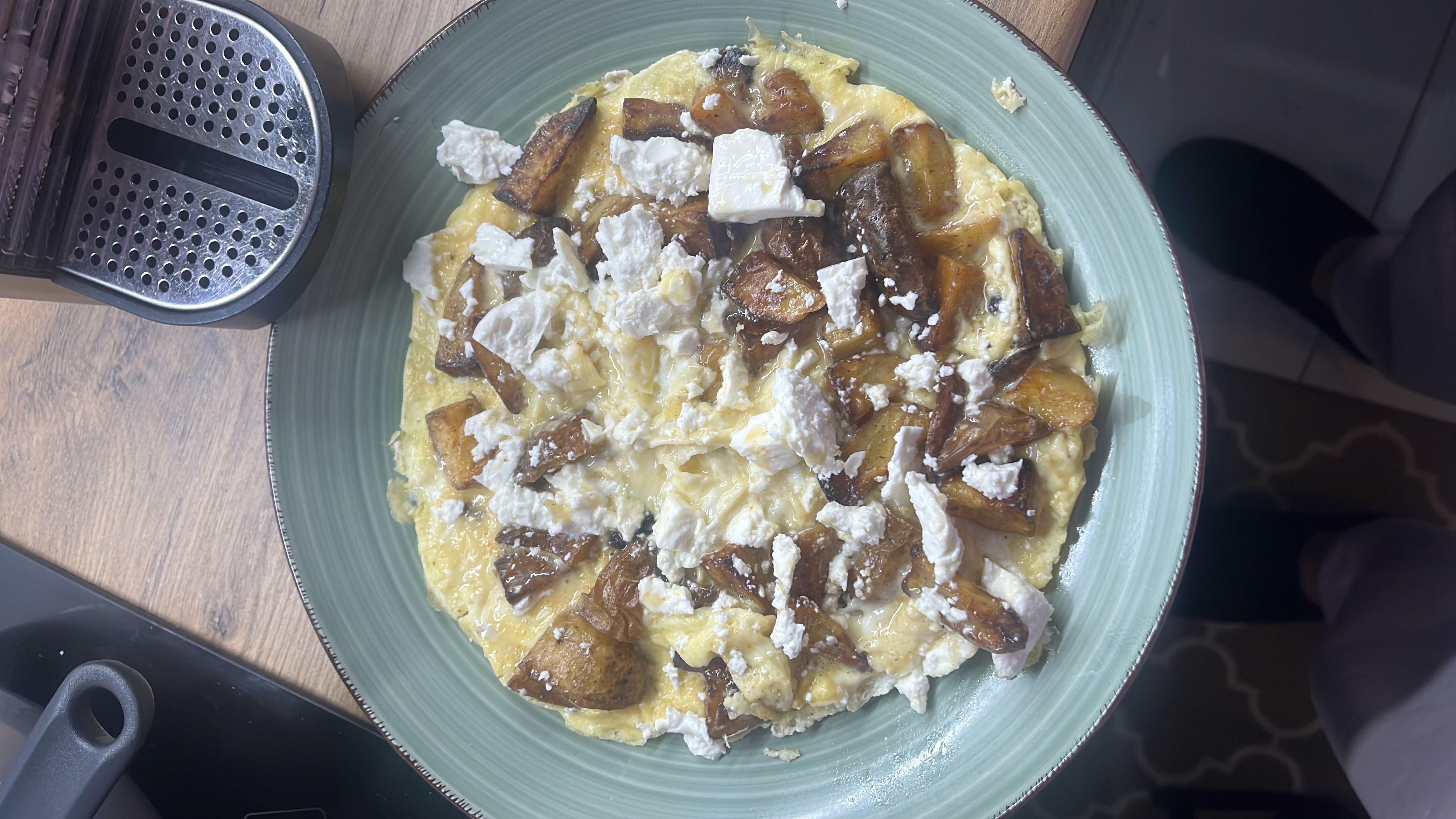A dish of four scrambled eggs with 70g baked potatoes and 50g feta cheese, providing a balanced mix of protein, carbohydrates, and fats.