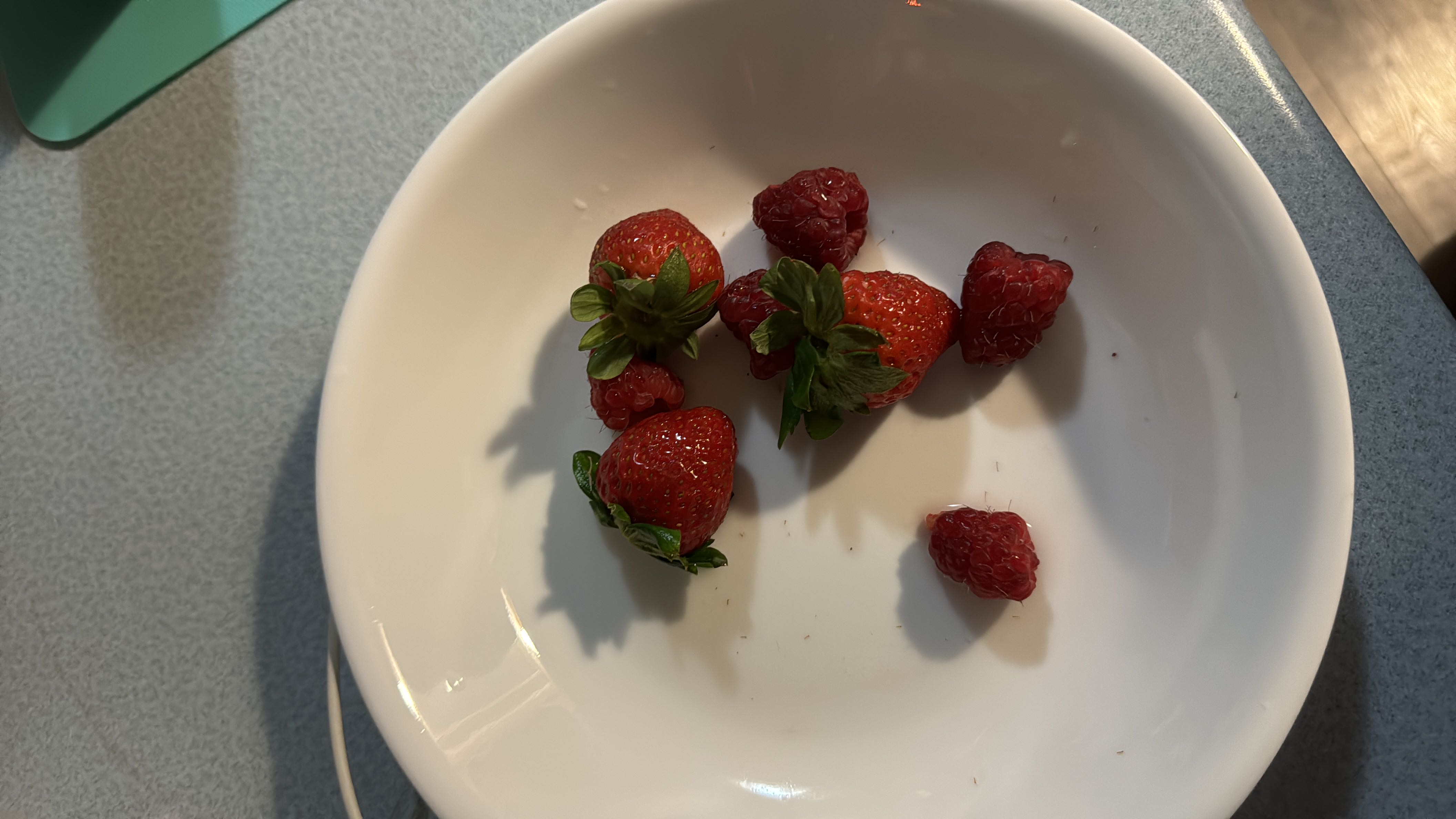 A bowl containing fresh strawberries and raspberries, which are low-calorie fruits rich in vitamins and antioxidants.