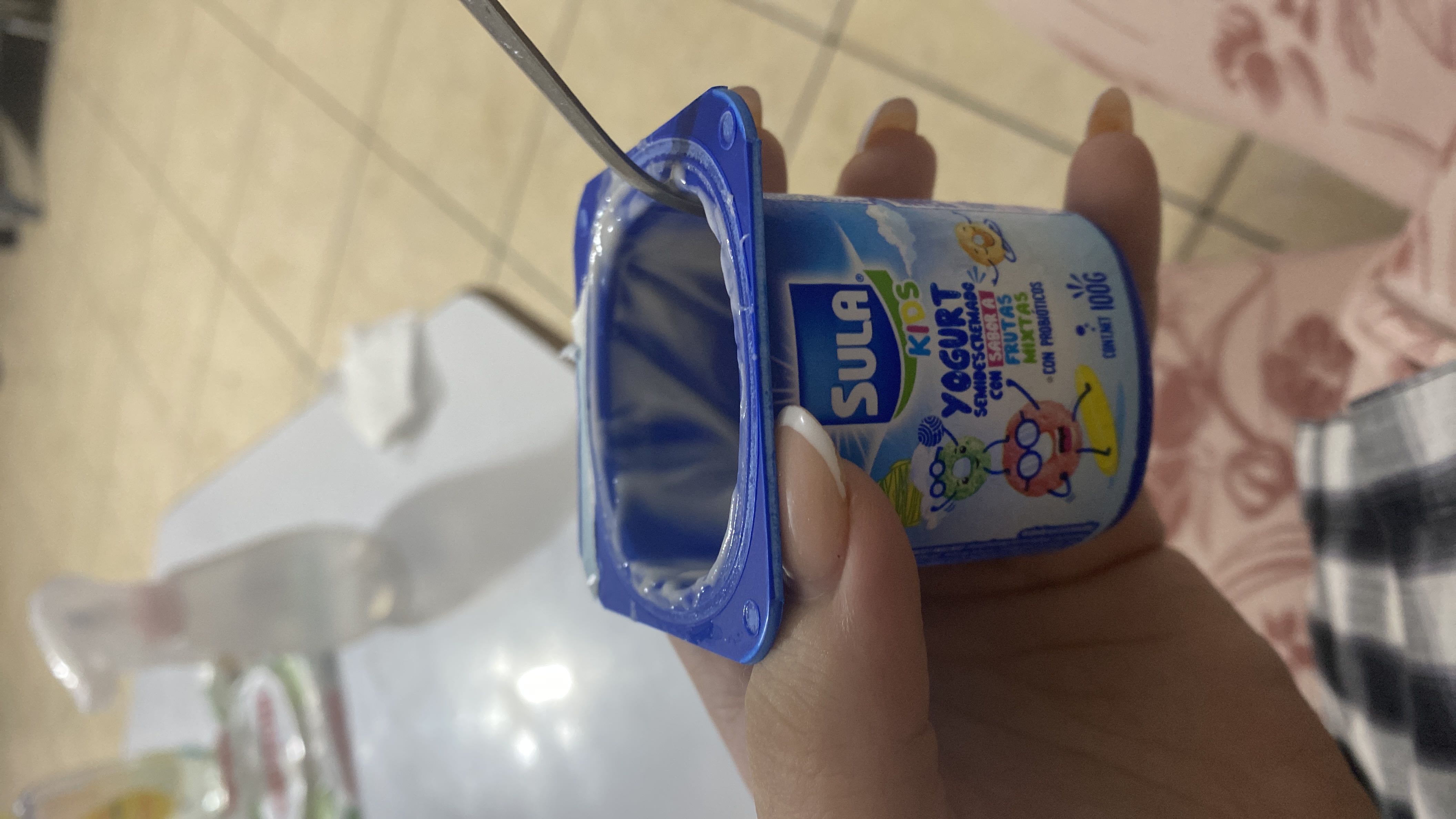 A 100g serving of semi-skimmed yogurt with mixed fruit flavor and probiotics, suitable for kids.