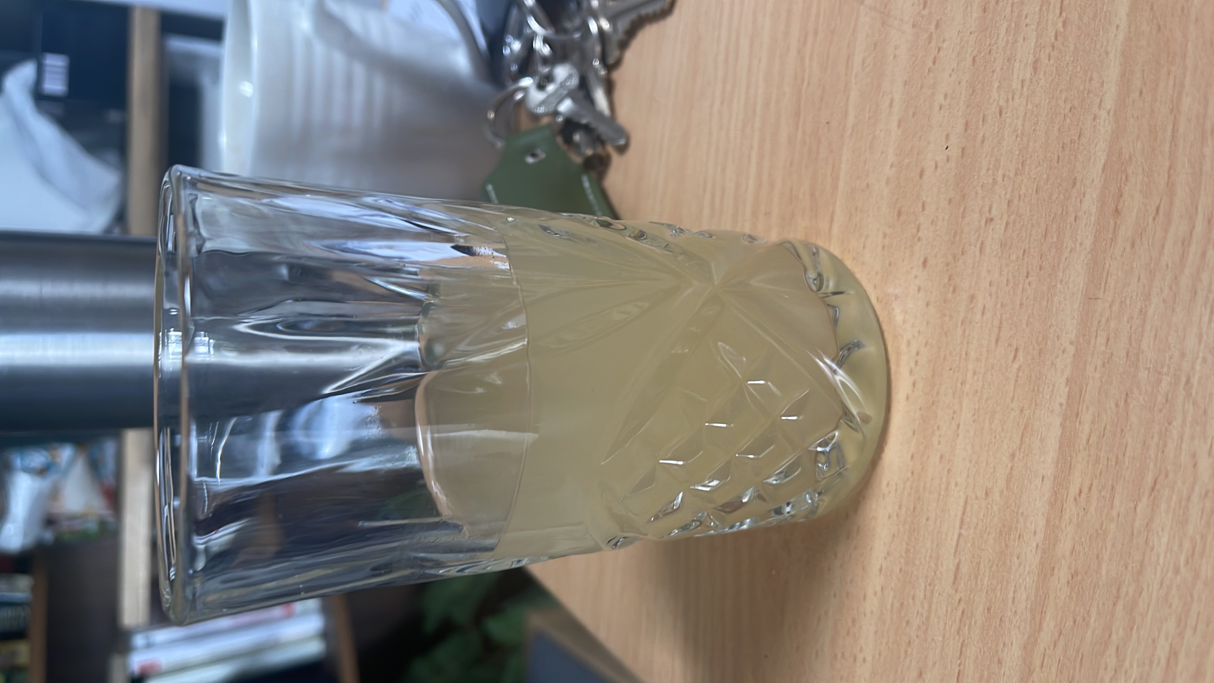 A glass of homemade lemonade, containing lemon juice, water, and sugar, with a light and refreshing appearance.