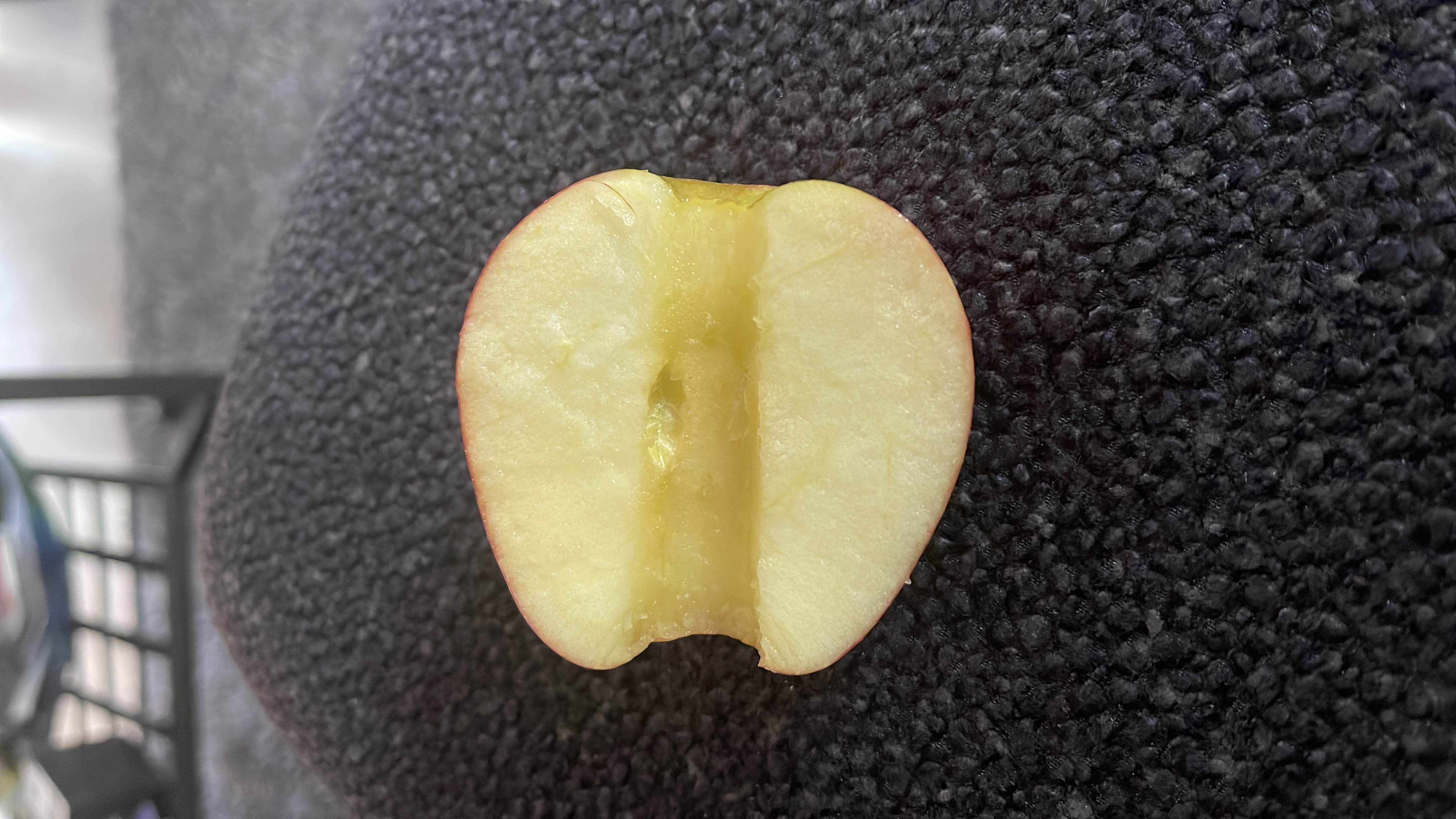 The image shows a halved apple, which is a low-calorie fruit rich in carbohydrates and fiber, making it a healthy snack option.