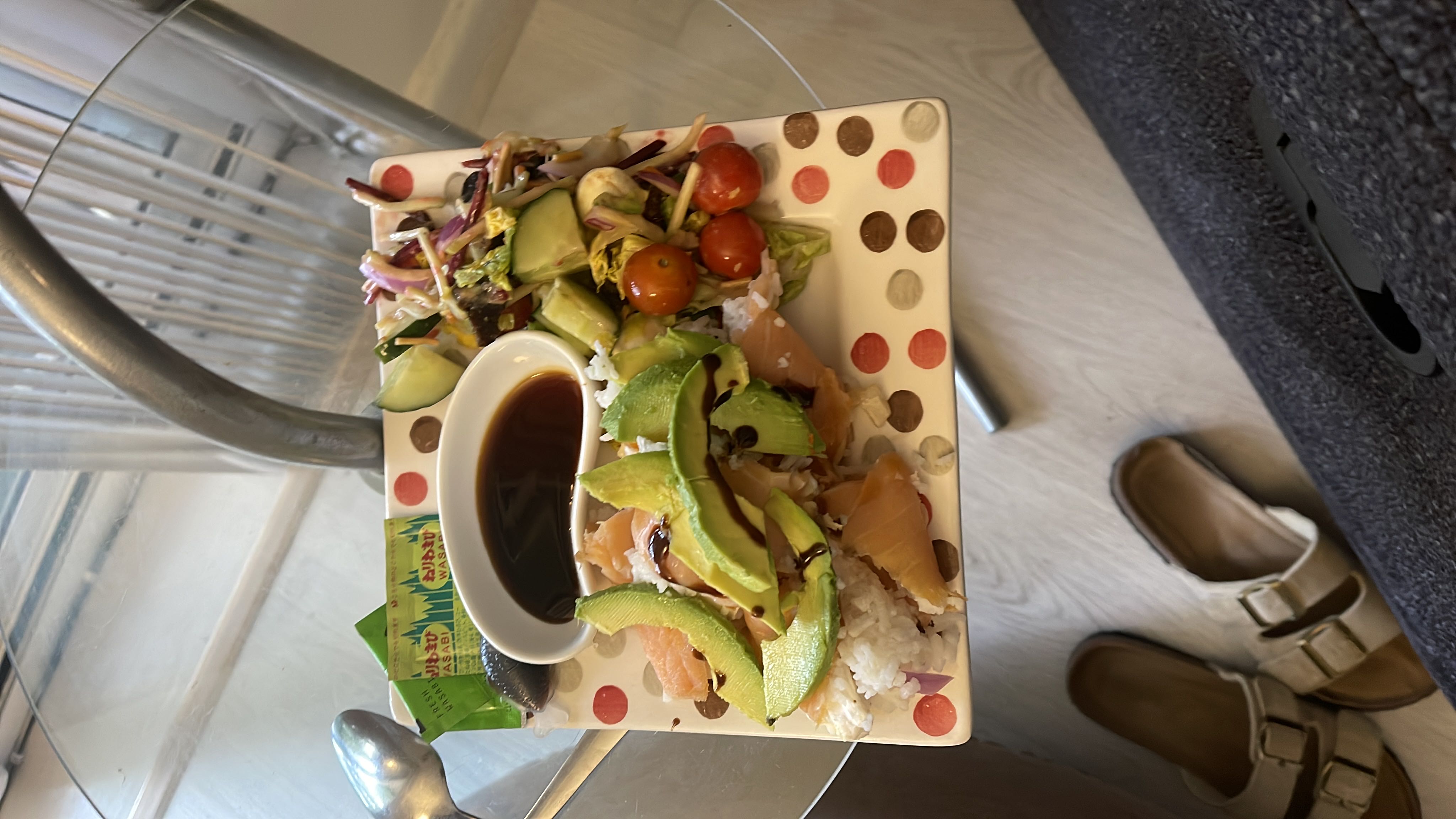 A balanced meal consisting of salmon, avocado, white rice, and a mixed salad, served with soy sauce and wasabi.
