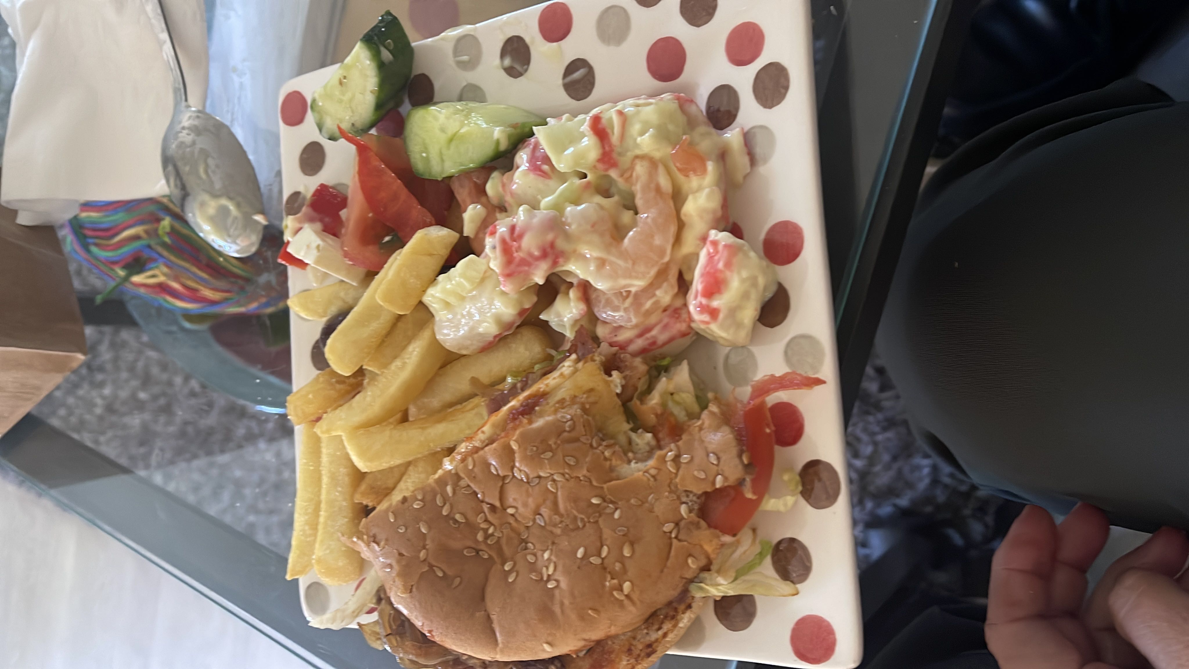 A meal consisting of a burger, french fries, and a side salad with dressing.