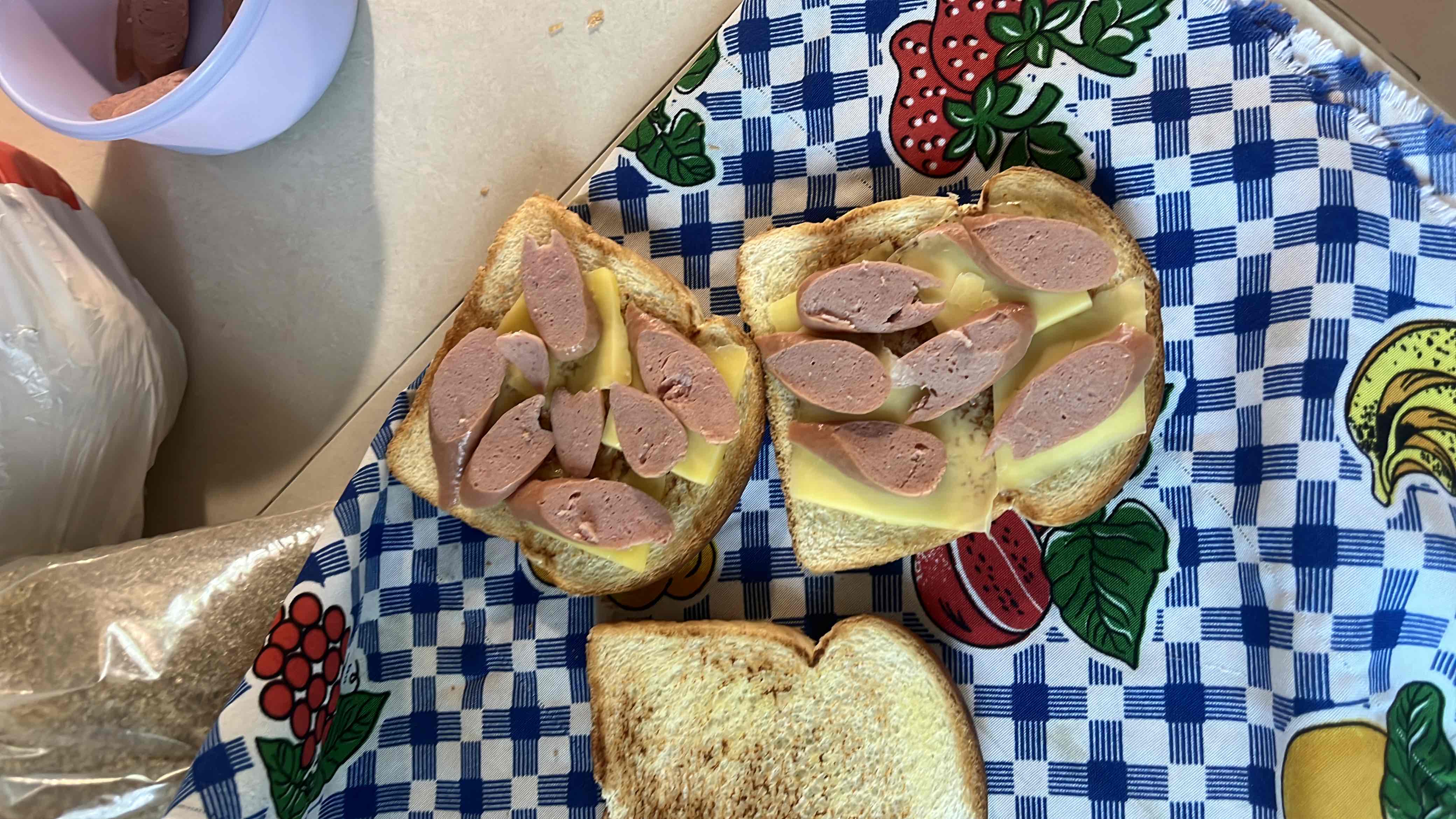 This is an open-faced sandwich made with bread, cheese slices, and sausage pieces, providing a moderate balance of calories, protein, carbs, and fats.