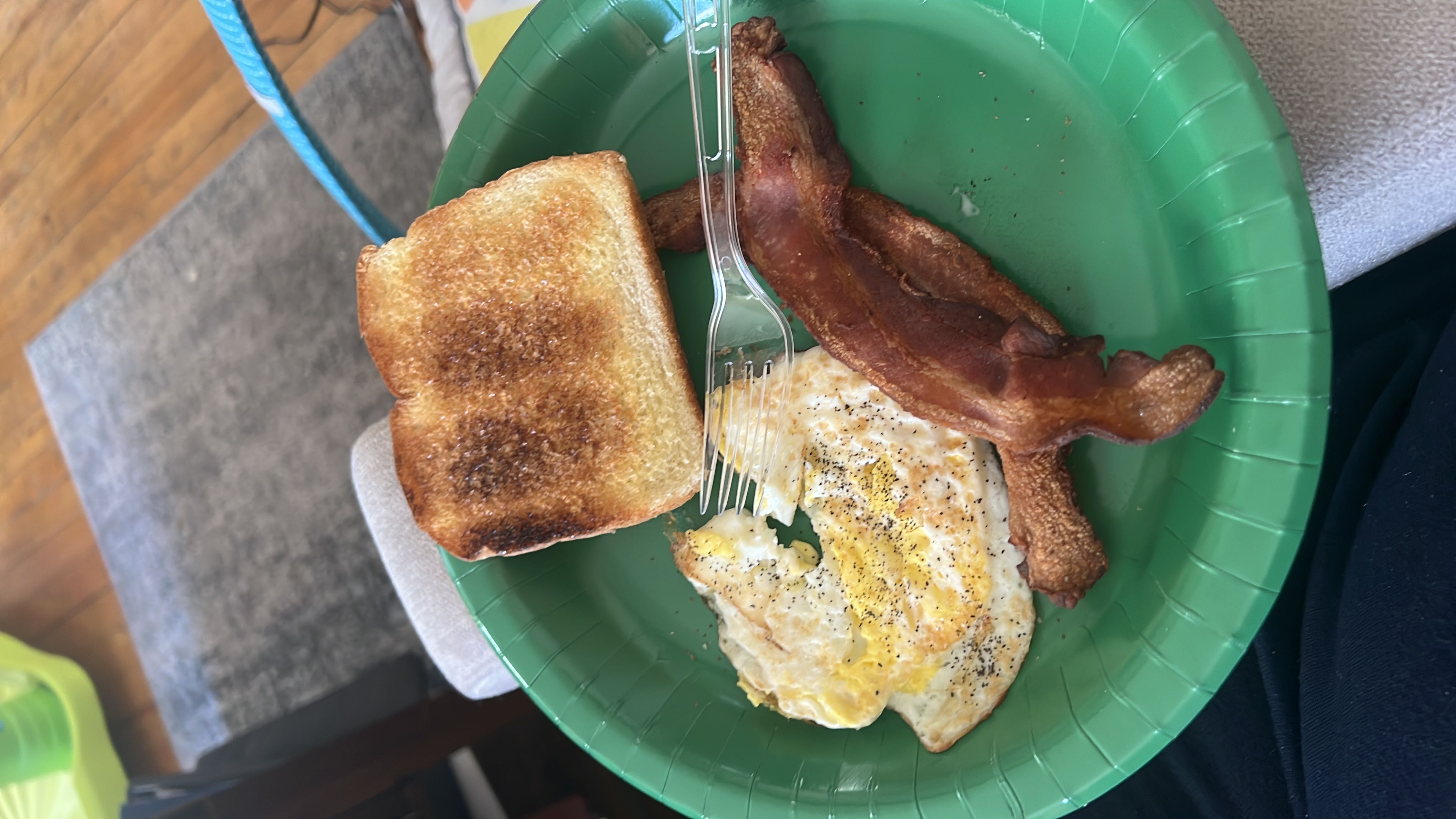 A breakfast plate containing fried eggs, bacon, and toast, providing a balanced mix of protein, fats, and carbohydrates.