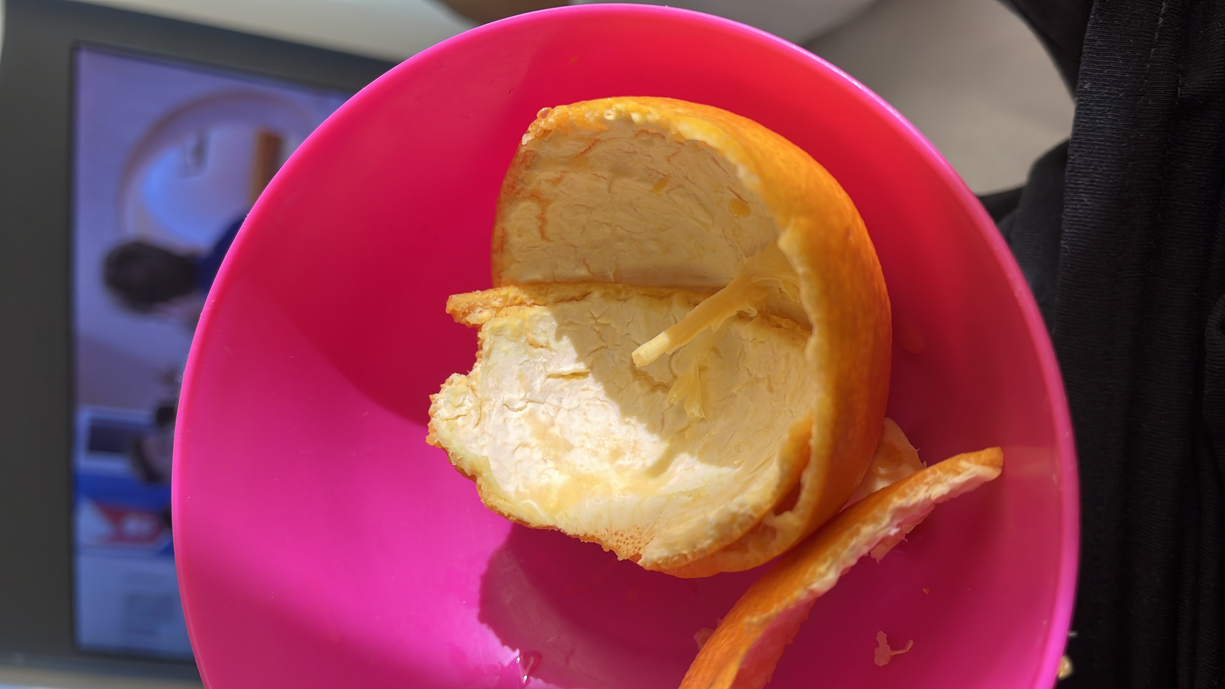 The image shows an orange peel in a bowl, indicating the consumption of an orange, which is a low-calorie, nutrient-rich fruit.