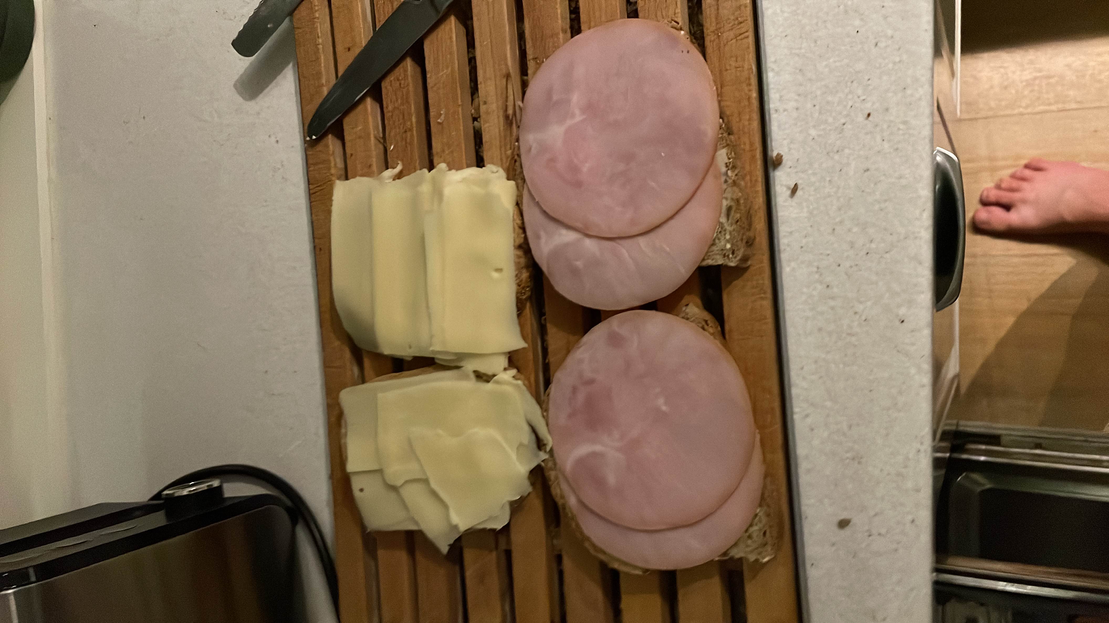 This image shows an open sandwich preparation with slices of ham, cheese, and bread, providing a balanced mix of protein, carbs, and fats.