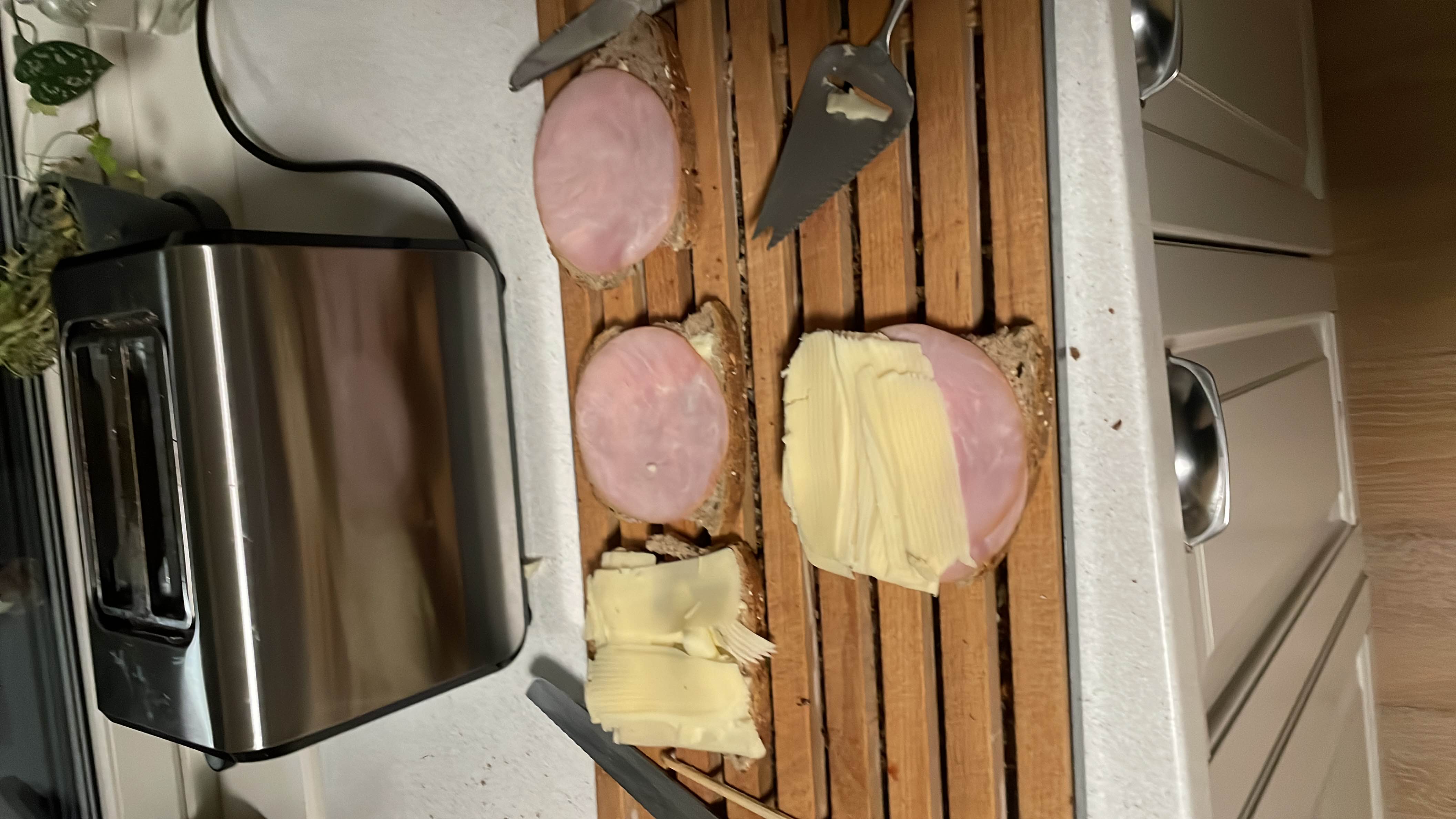 The image shows open-faced sandwiches made with whole grain bread, ham, and butter, providing a balanced mix of carbs, protein, and fats.