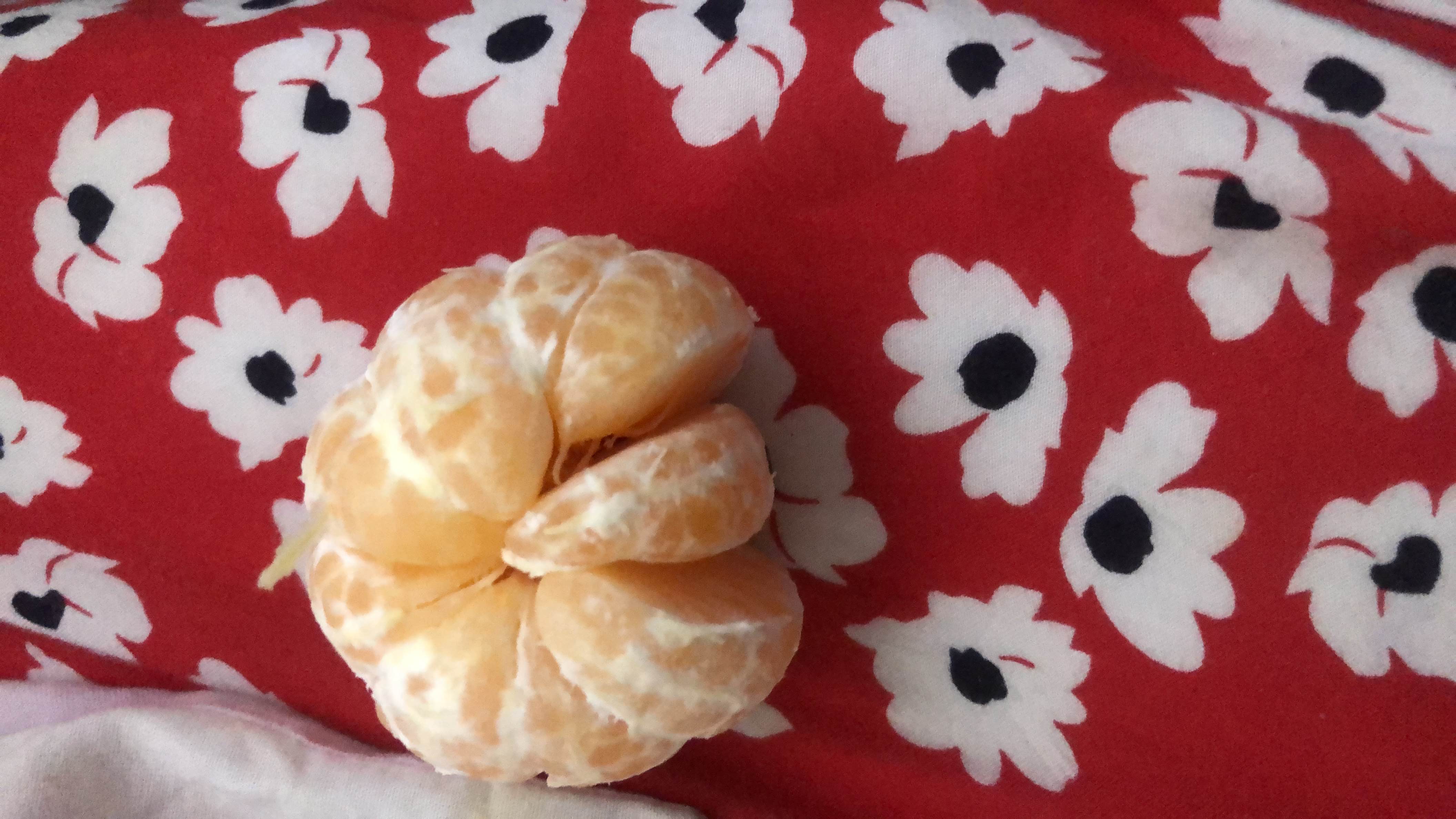 The image shows a peeled mandarin orange, a low-calorie fruit rich in vitamin C and dietary fiber.