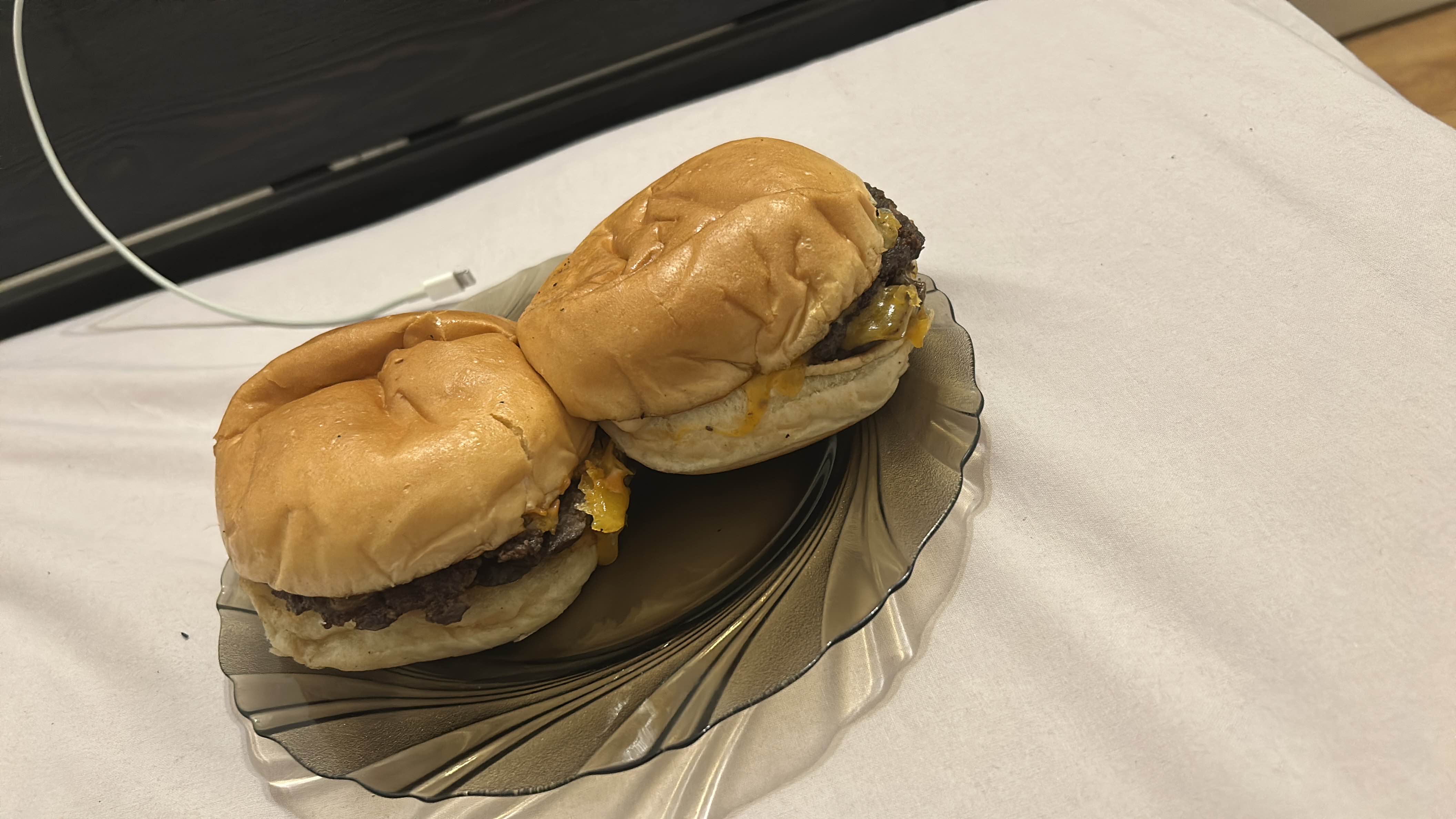 The image shows two cheeseburgers with beef patties, cheese, and buns, served on a plate.