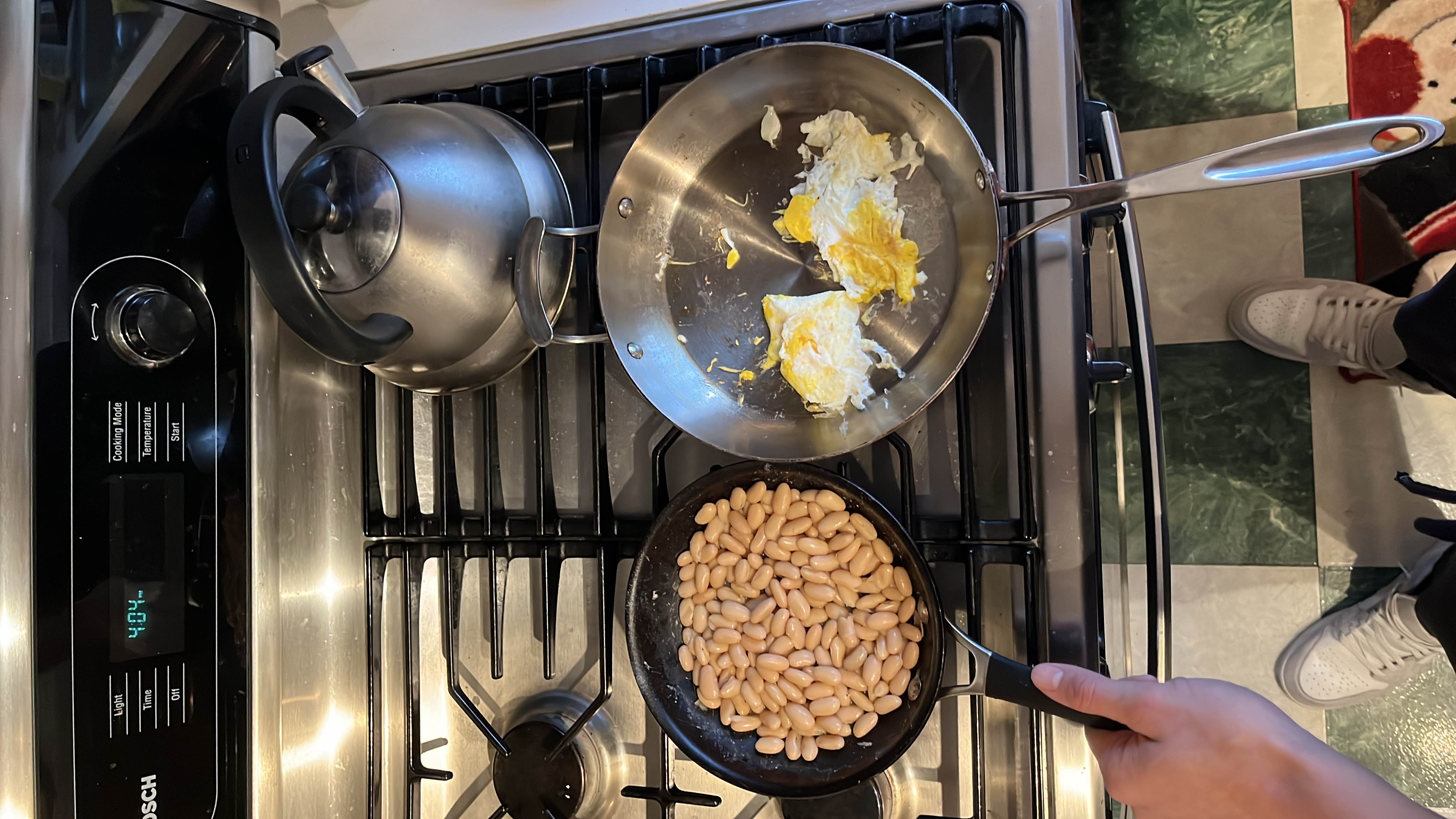 A simple meal consisting of cooked beans and fried eggs, providing a balanced mix of protein, carbs, and fats.