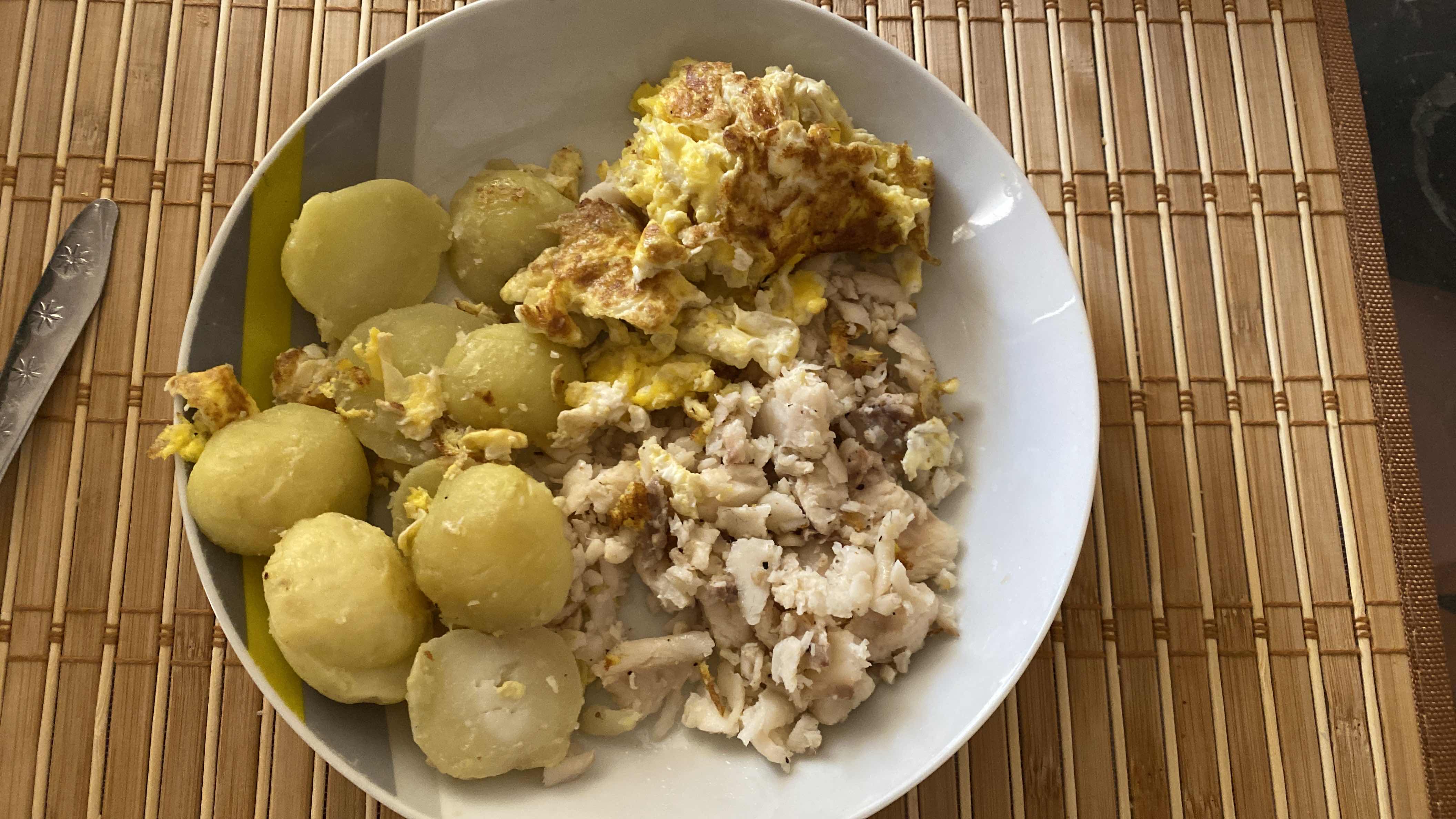 A balanced meal consisting of boiled potatoes, scrambled eggs, and cooked fish, providing a good mix of protein, carbohydrates, and fats.