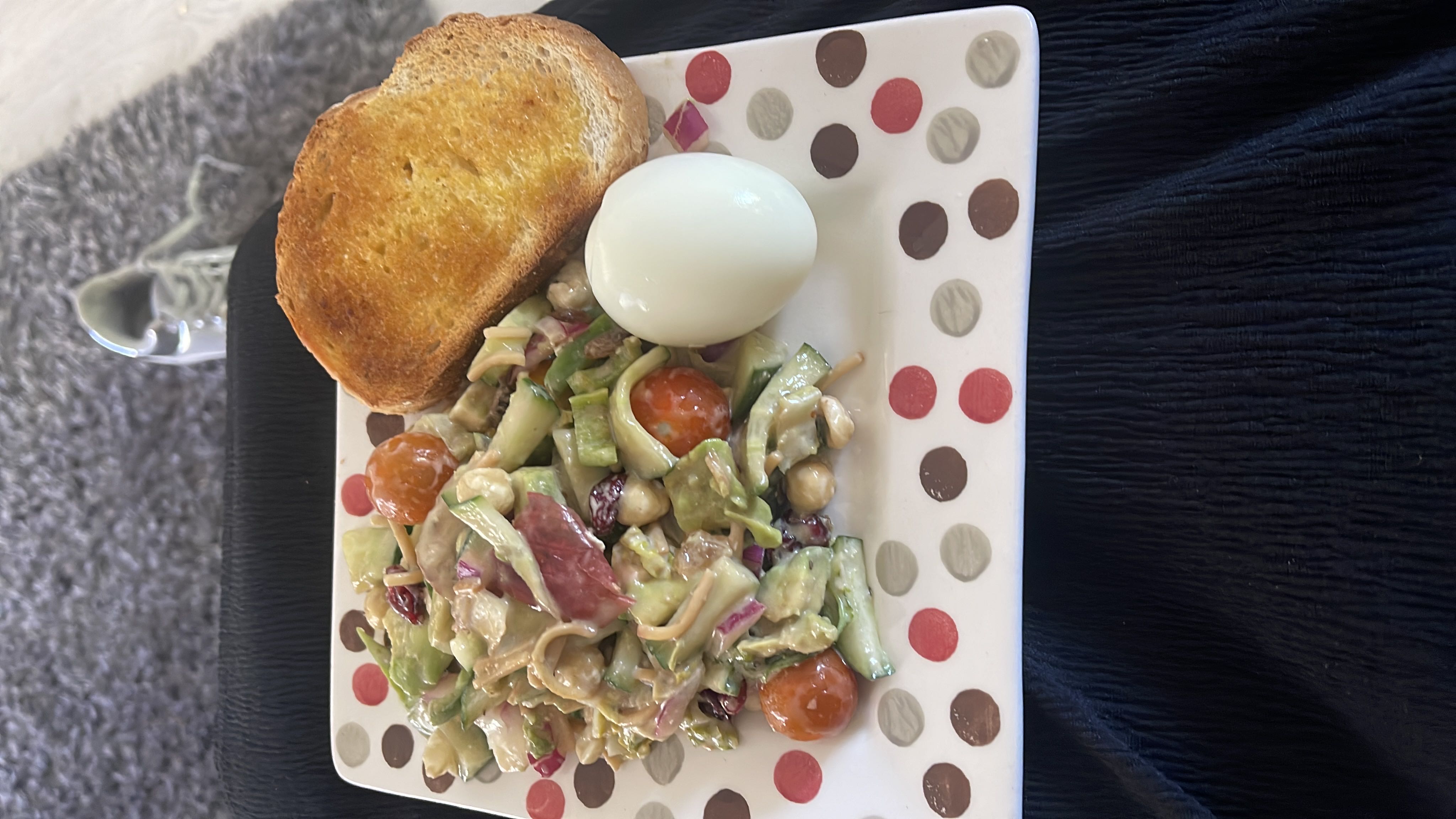 A balanced meal consisting of a fresh salad, a boiled egg, and a slice of toasted bread.
