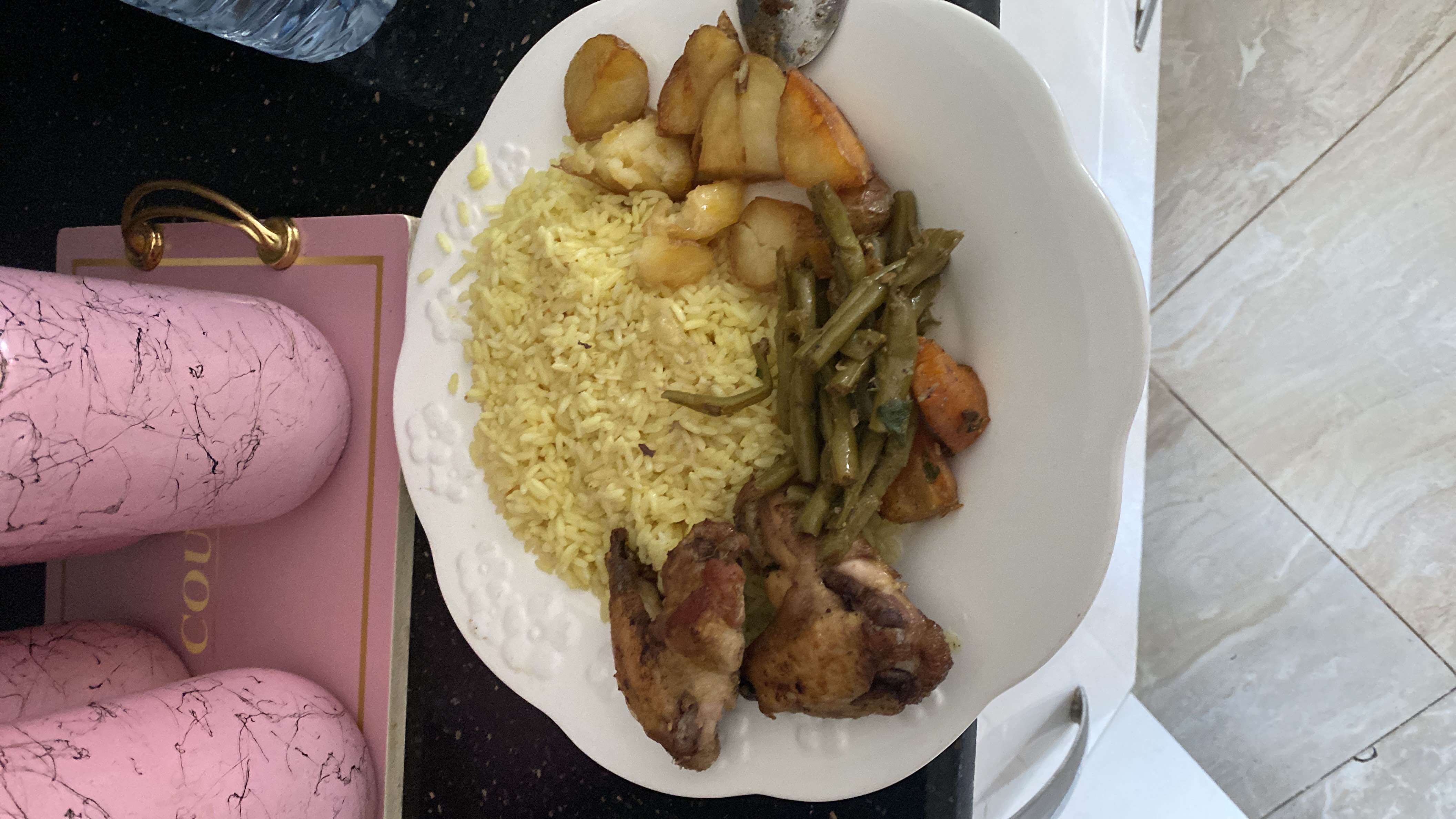 A balanced meal consisting of roasted chicken, yellow rice, sautéed green beans, and roasted potatoes.