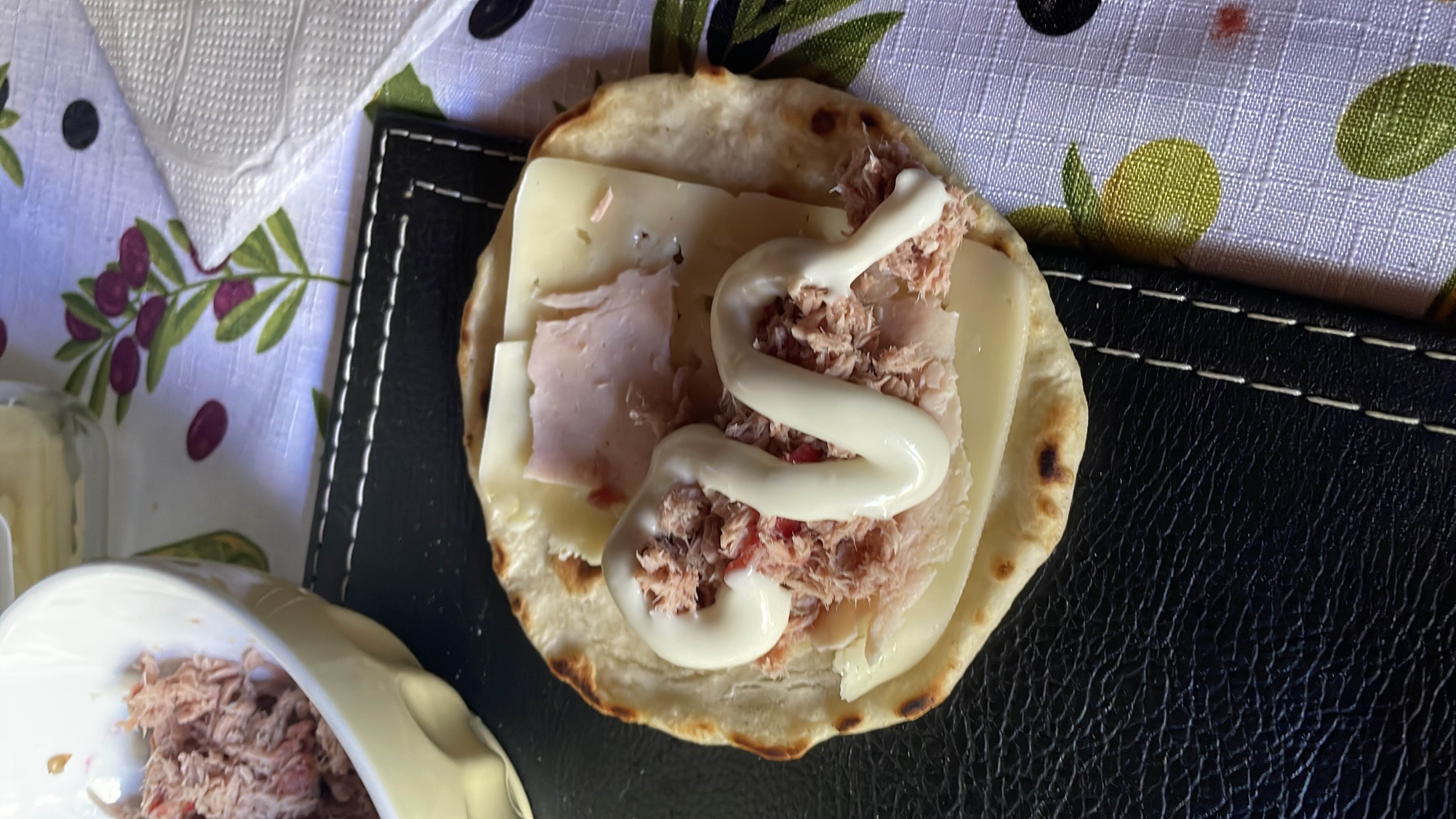 A tortilla wrap with cheese, tuna, and mayonnaise, providing a balanced mix of protein, carbs, and fats.