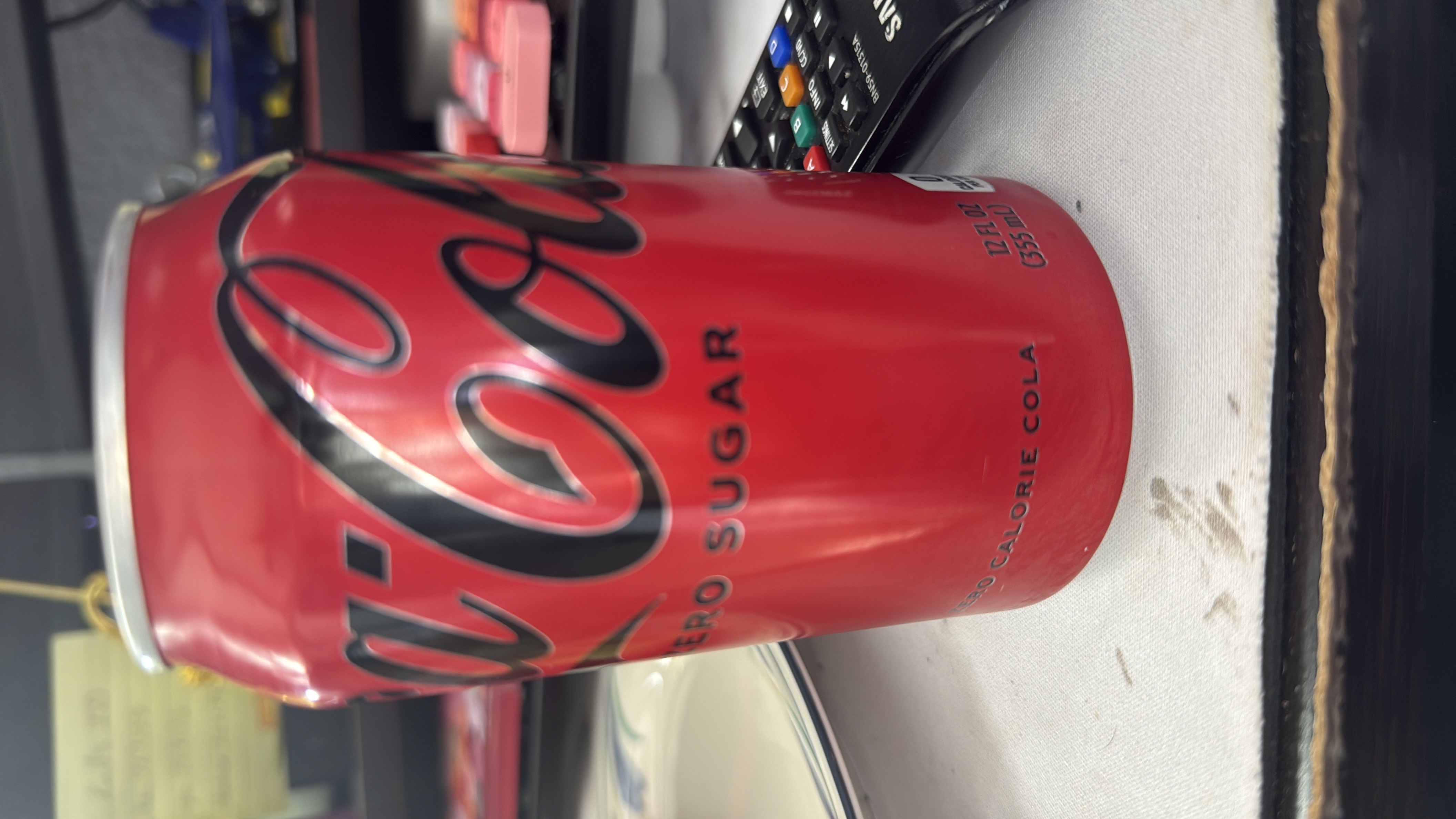 A can of Coca-Cola Zero Sugar, a zero-calorie cola beverage with no fats, carbs, or protein.
