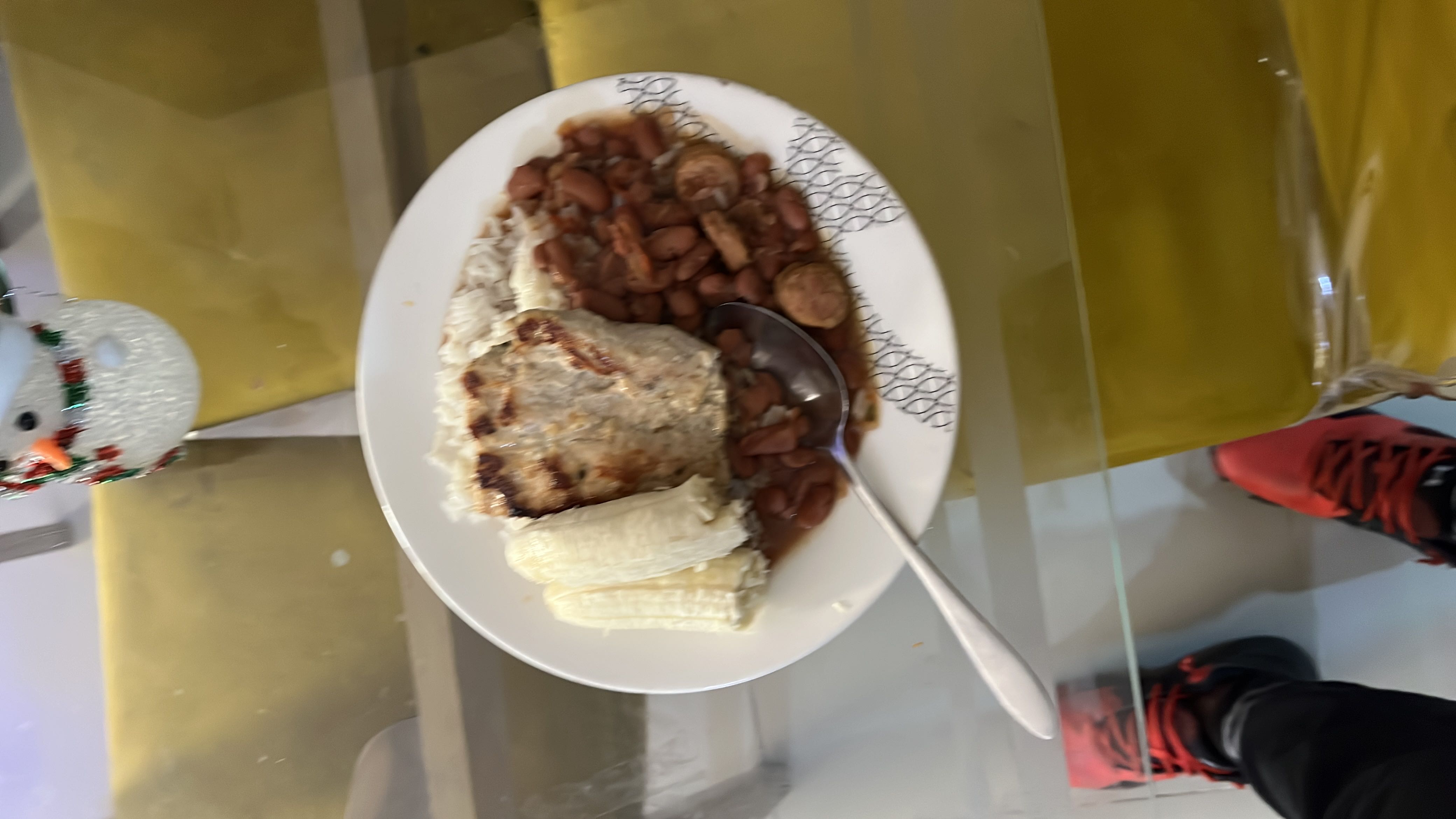A balanced meal consisting of grilled chicken, white rice, beans, and banana, providing a mix of protein, carbohydrates, and fats.