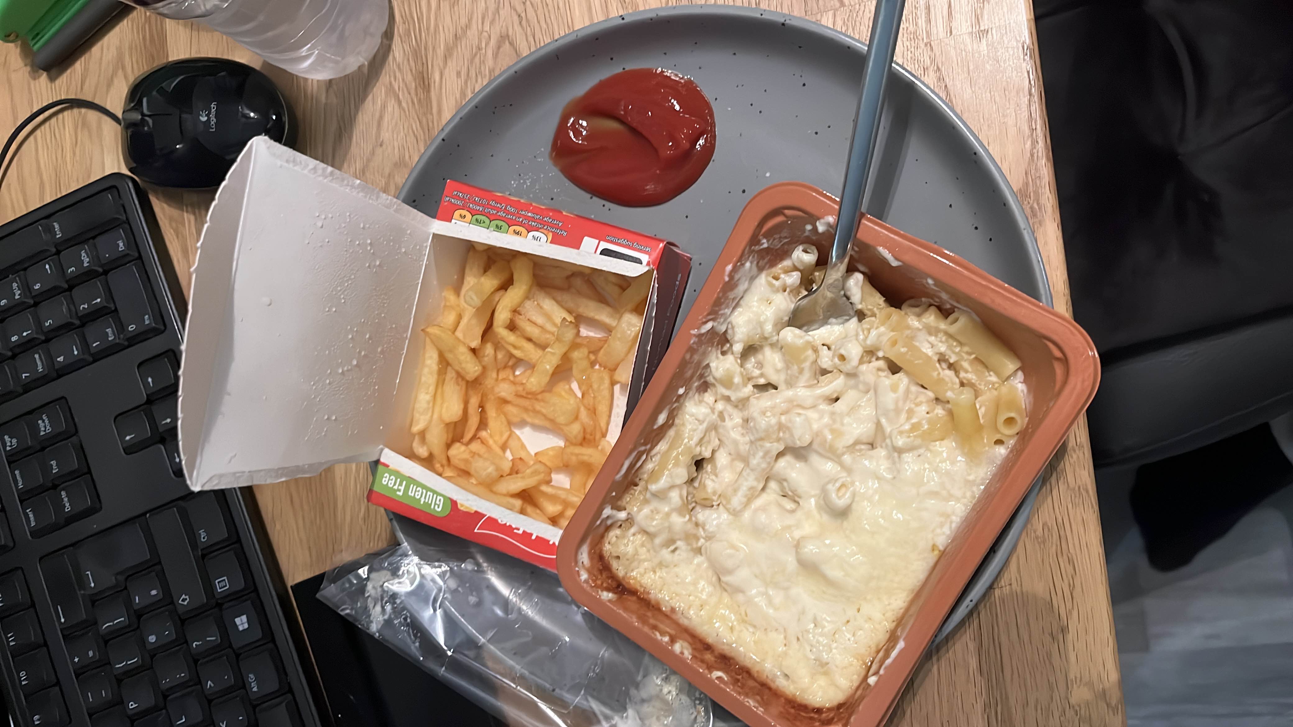 A meal consisting of macaroni and cheese, French fries, and ketchup, providing a moderate balance of carbs, fats, and protein.