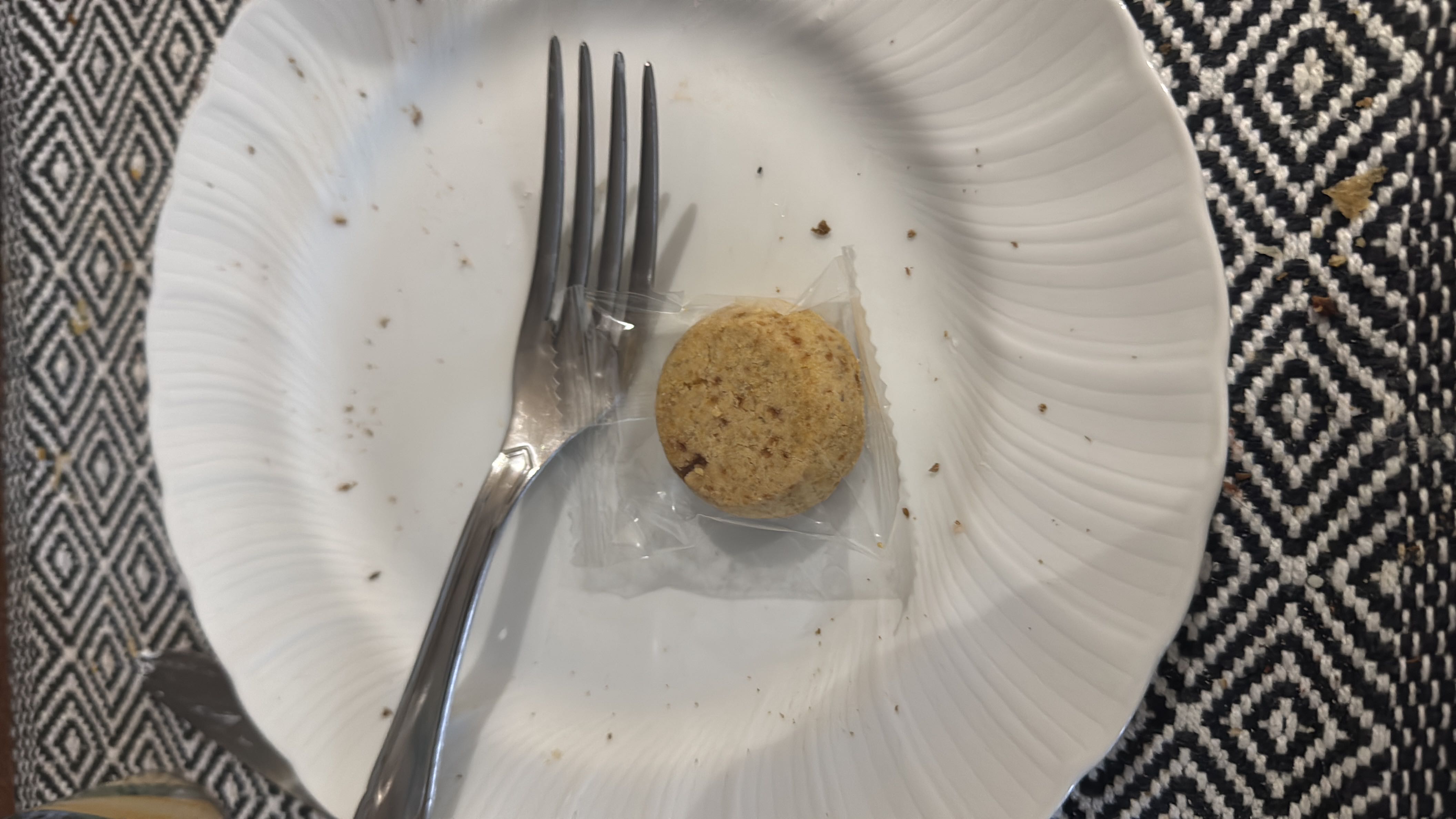 A single packaged cookie on a plate, likely a small snack with moderate nutritional value.