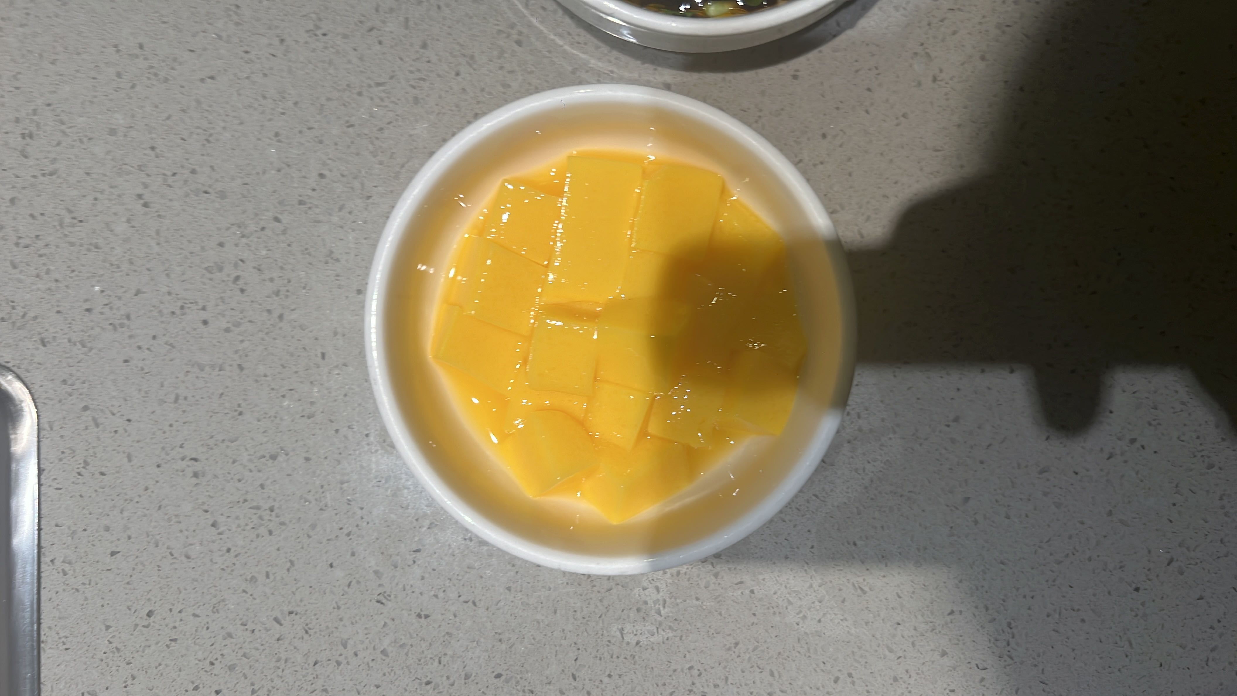 A bowl of diced mangoes, a low-calorie fruit rich in carbohydrates and vitamins.