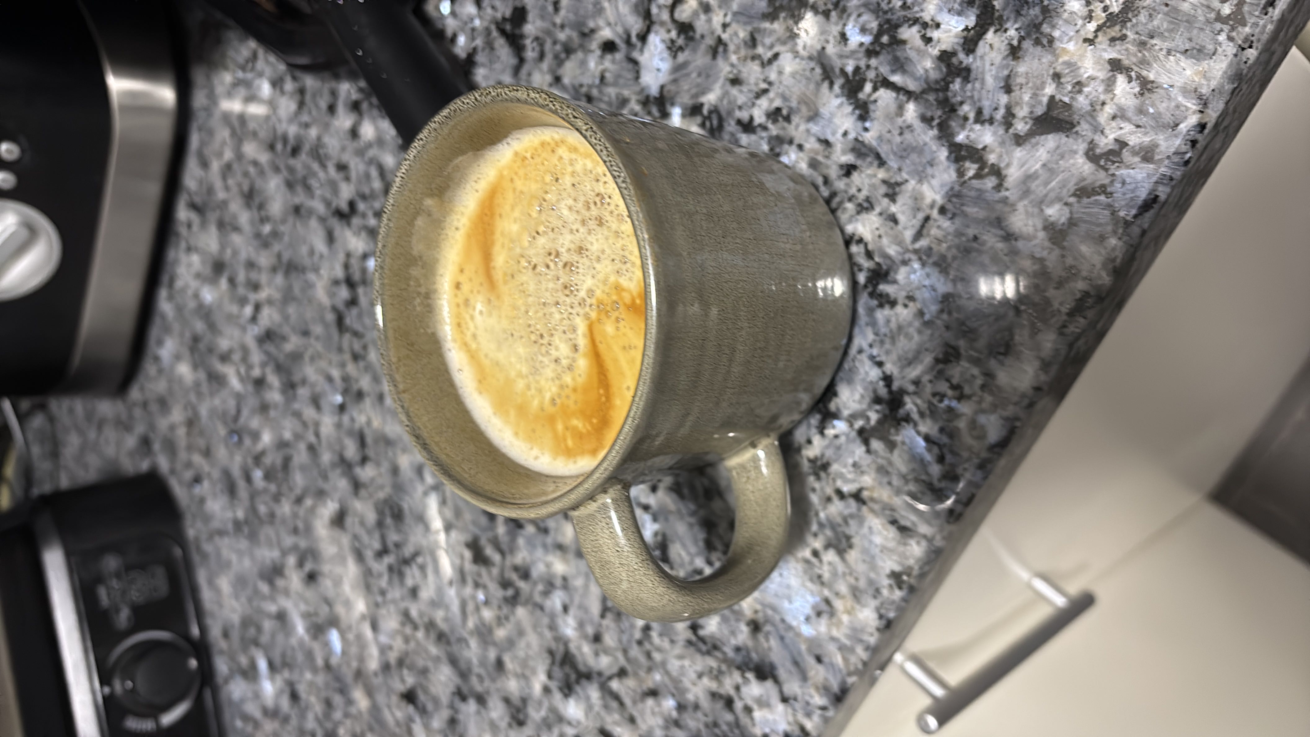 A cup of coffee with a light crema on top.