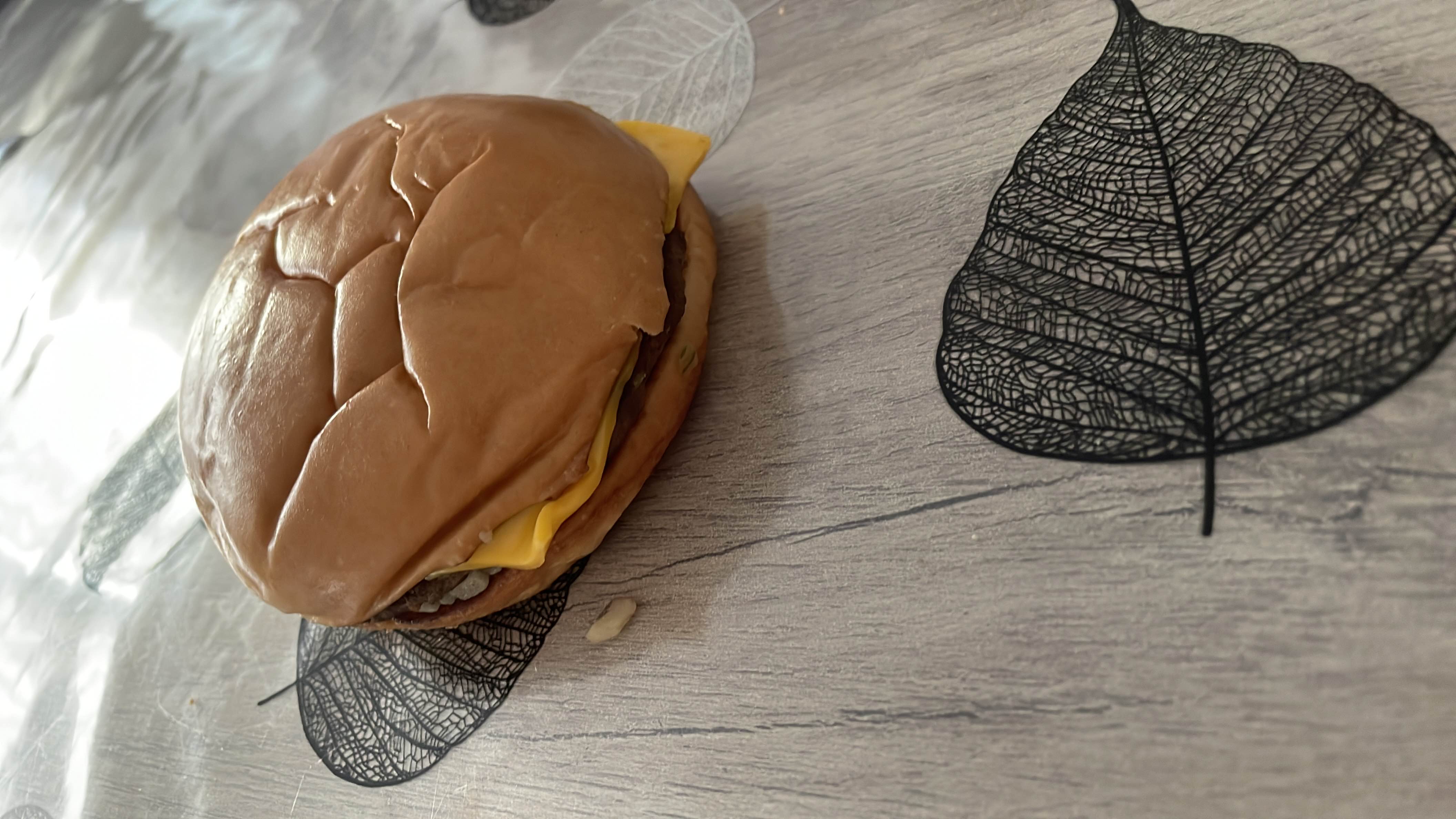 A cheeseburger featuring a soft bun, a beef patty, and a slice of cheese.