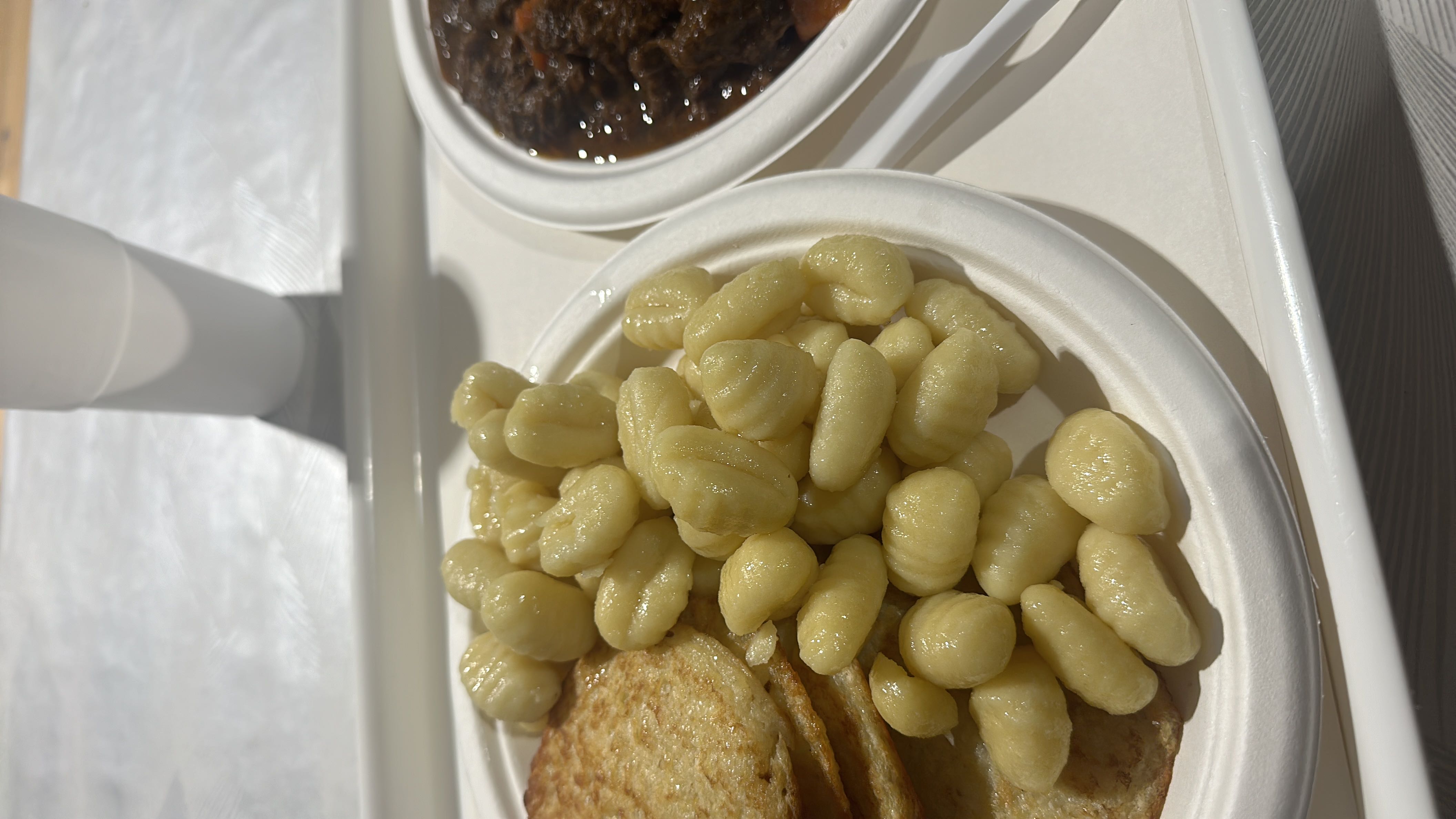 A plate of gnocchi, pancakes, and beef stew offering a moderate balance of protein, carbs, and fats.