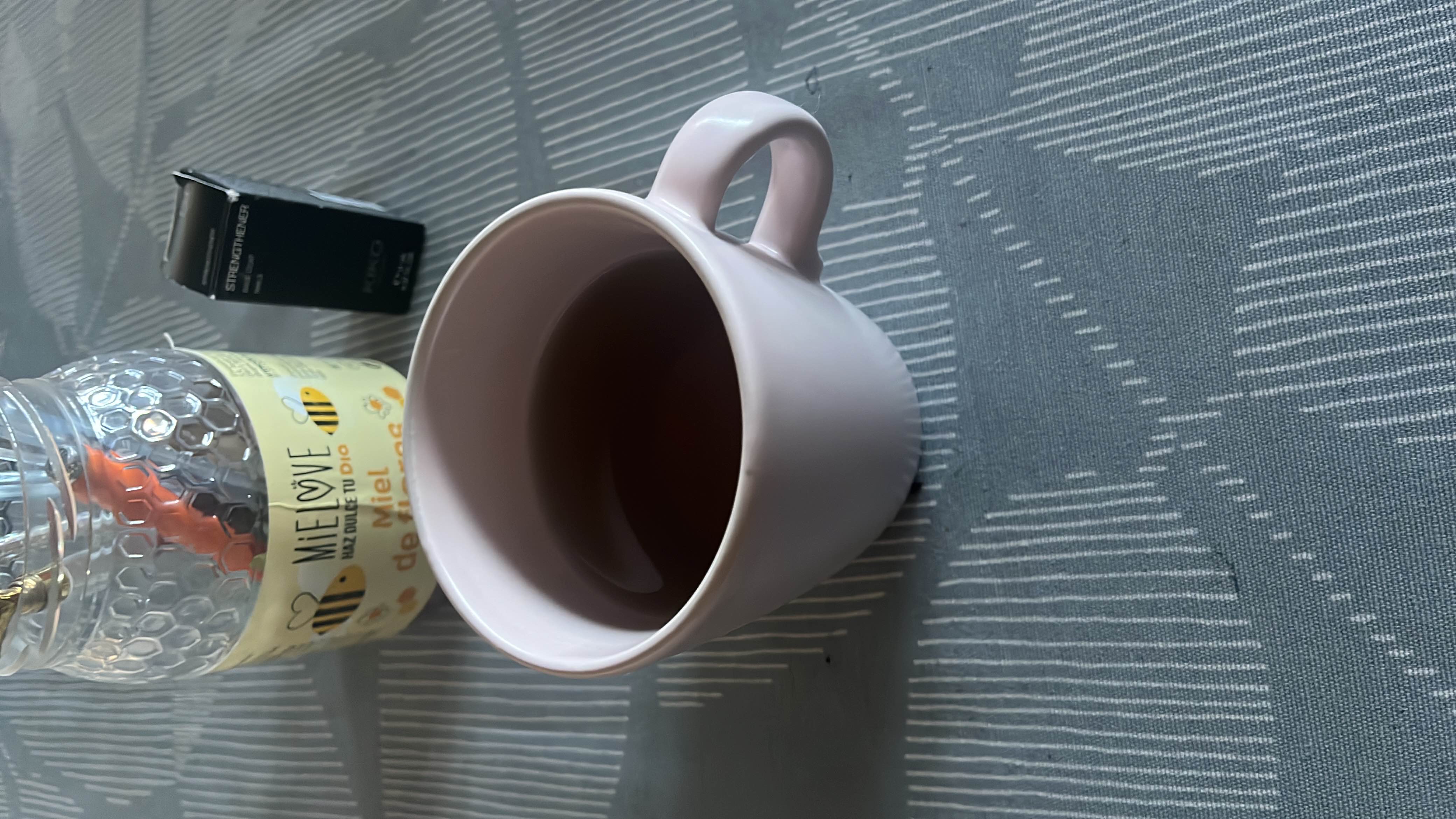 A cup of manzanilla tea, providing minimal calories with no significant amounts of protein, carbs, or fats.