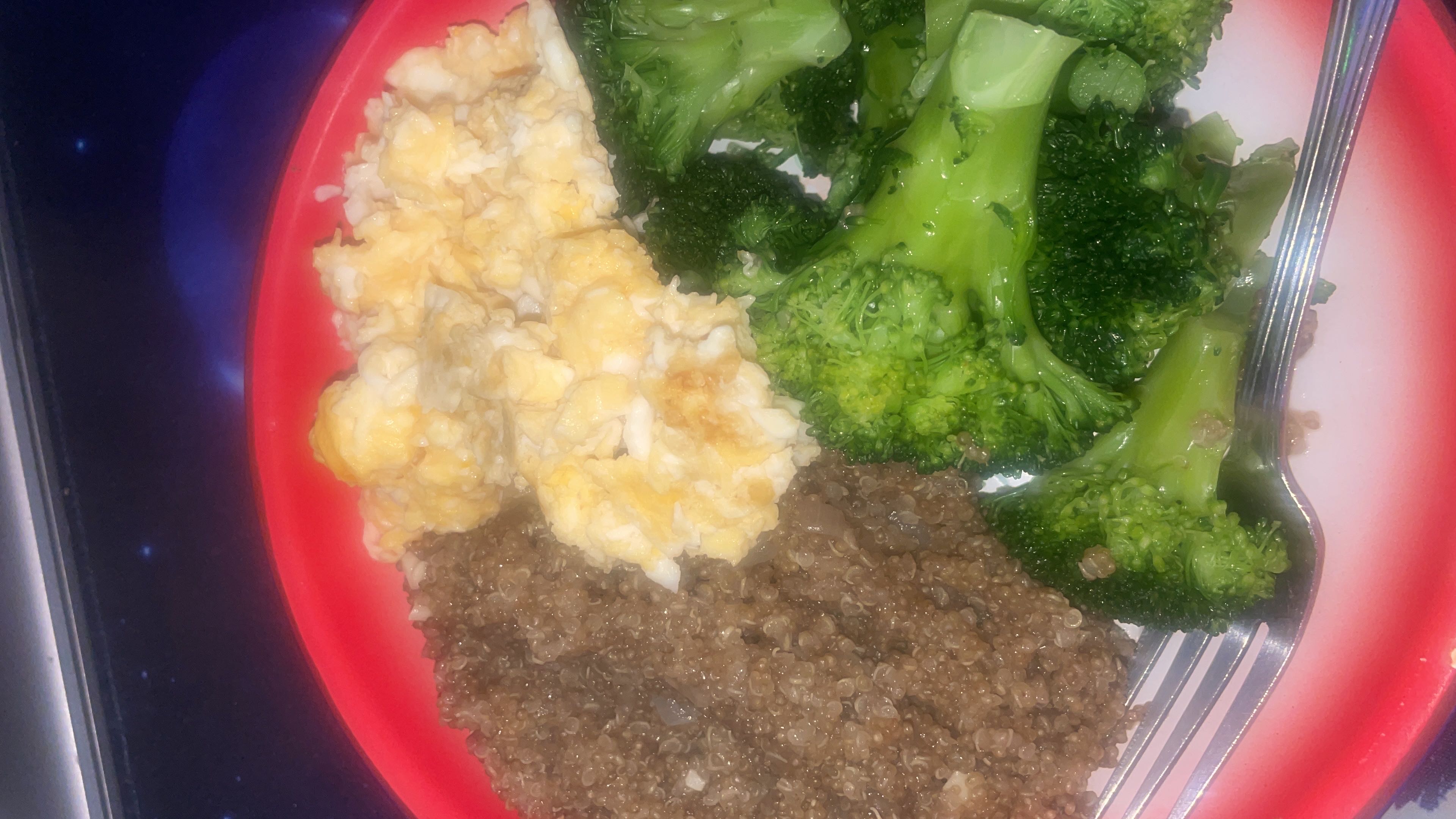 A balanced meal consisting of quinoa, scrambled eggs, and steamed broccoli, providing a good mix of protein, carbs, and fats.