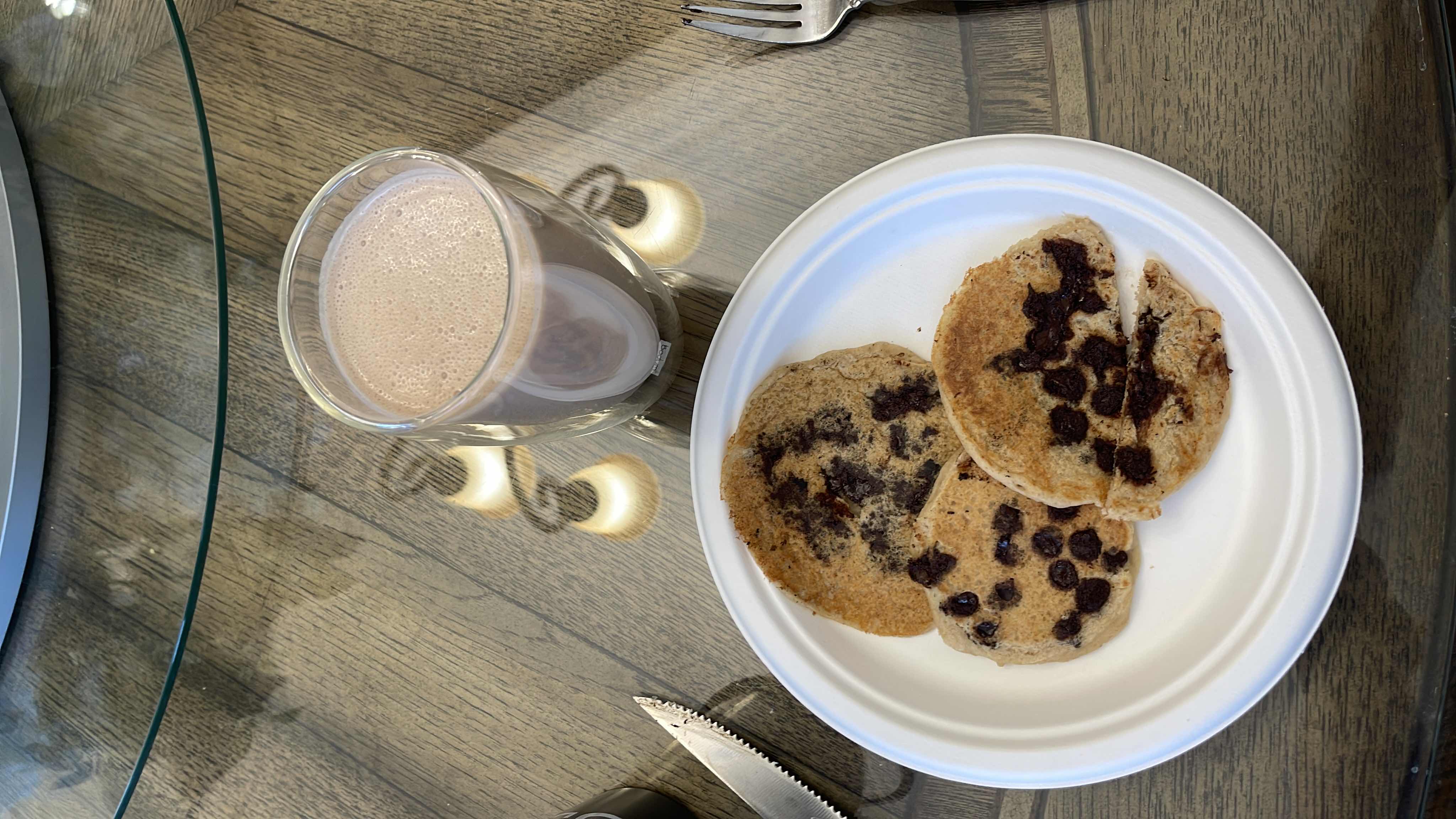 Protein-rich pancakes and two protein shakes made with protein powder, peanut butter, and milk, offering a high-protein, balanced meal.