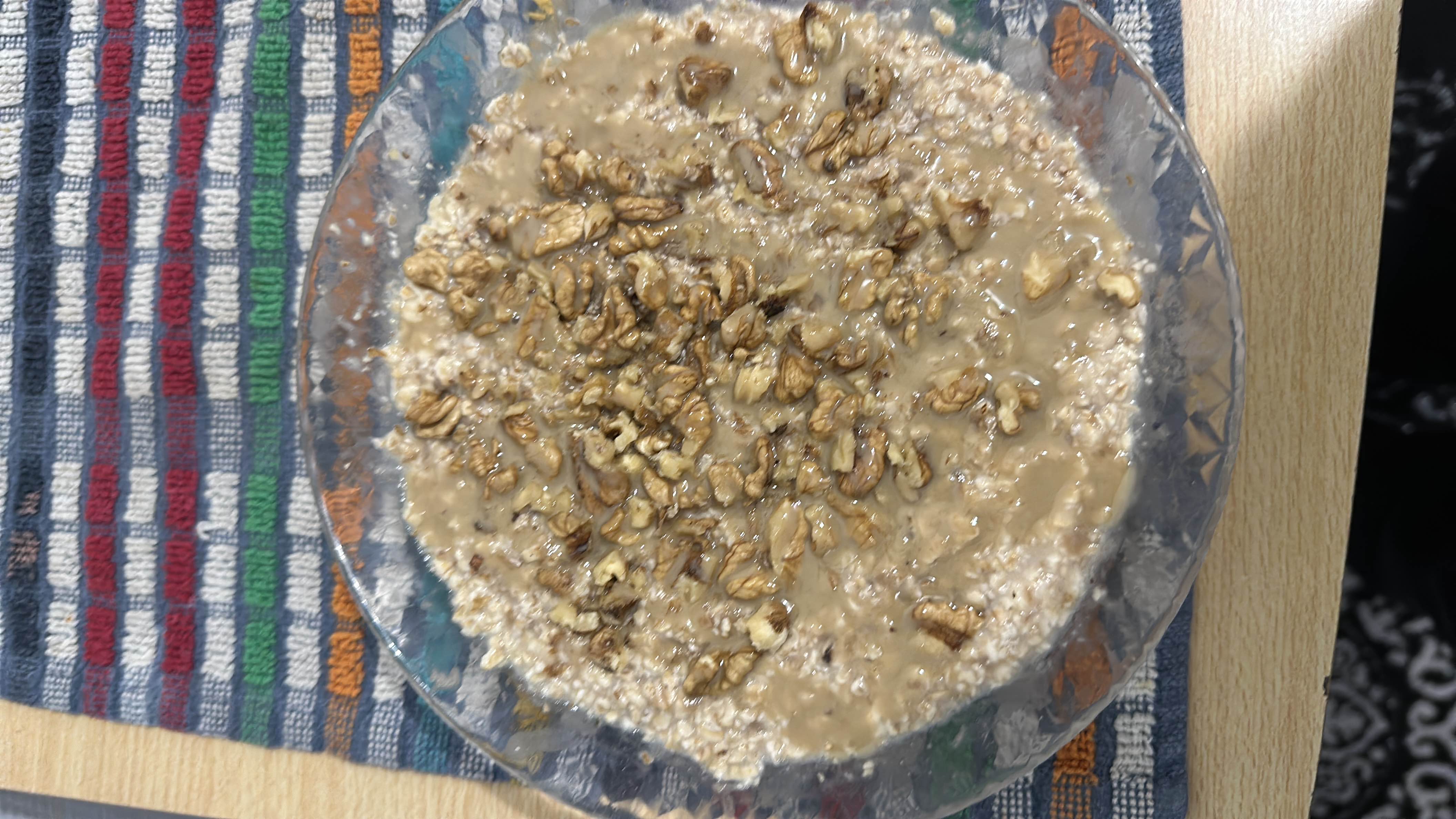 A nutritious dish consisting of oats topped with walnuts and peanut butter, providing a balanced mix of protein, carbs, and healthy fats.