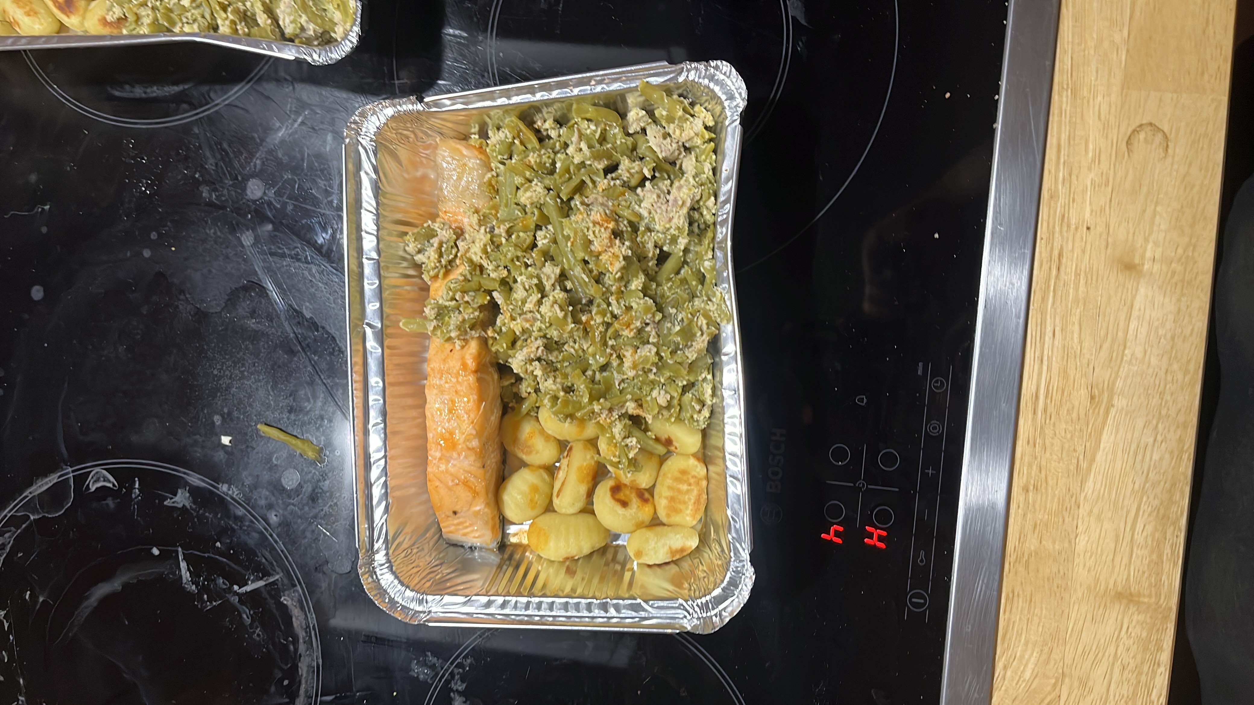 A balanced meal consisting of baked salmon, pan-fried gnocchi, and green beans mixed with tuna.