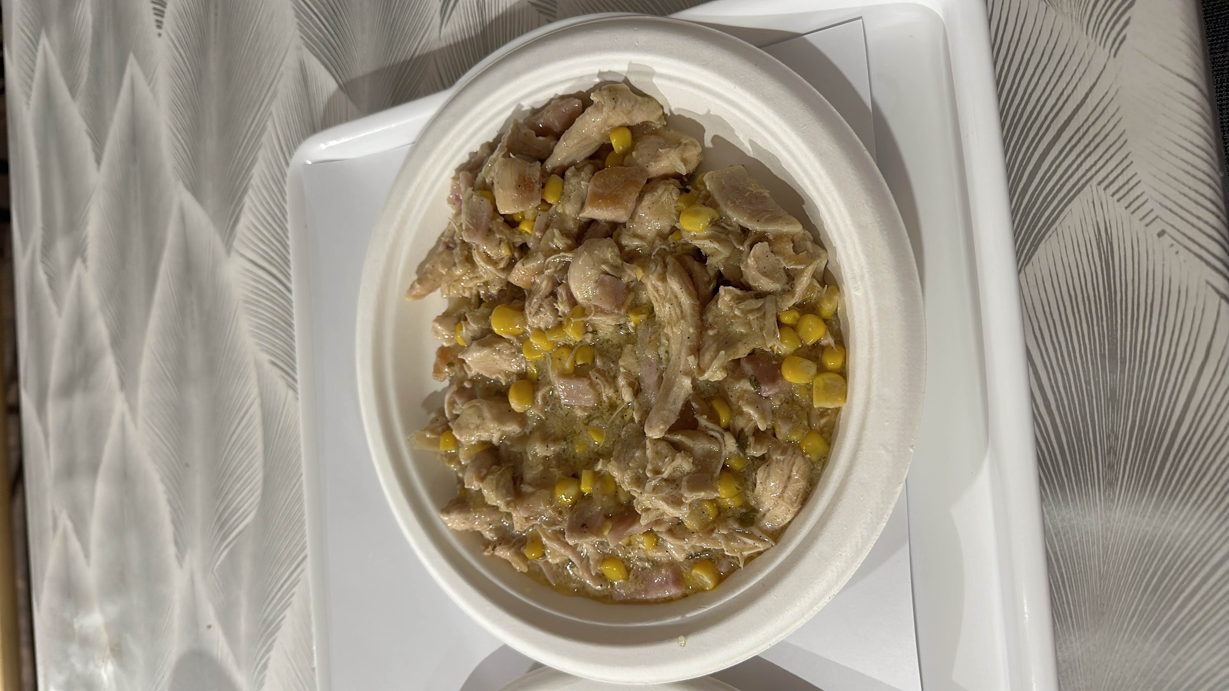 A dish consisting of shredded chicken, corn, and a creamy sauce, served in a bowl.