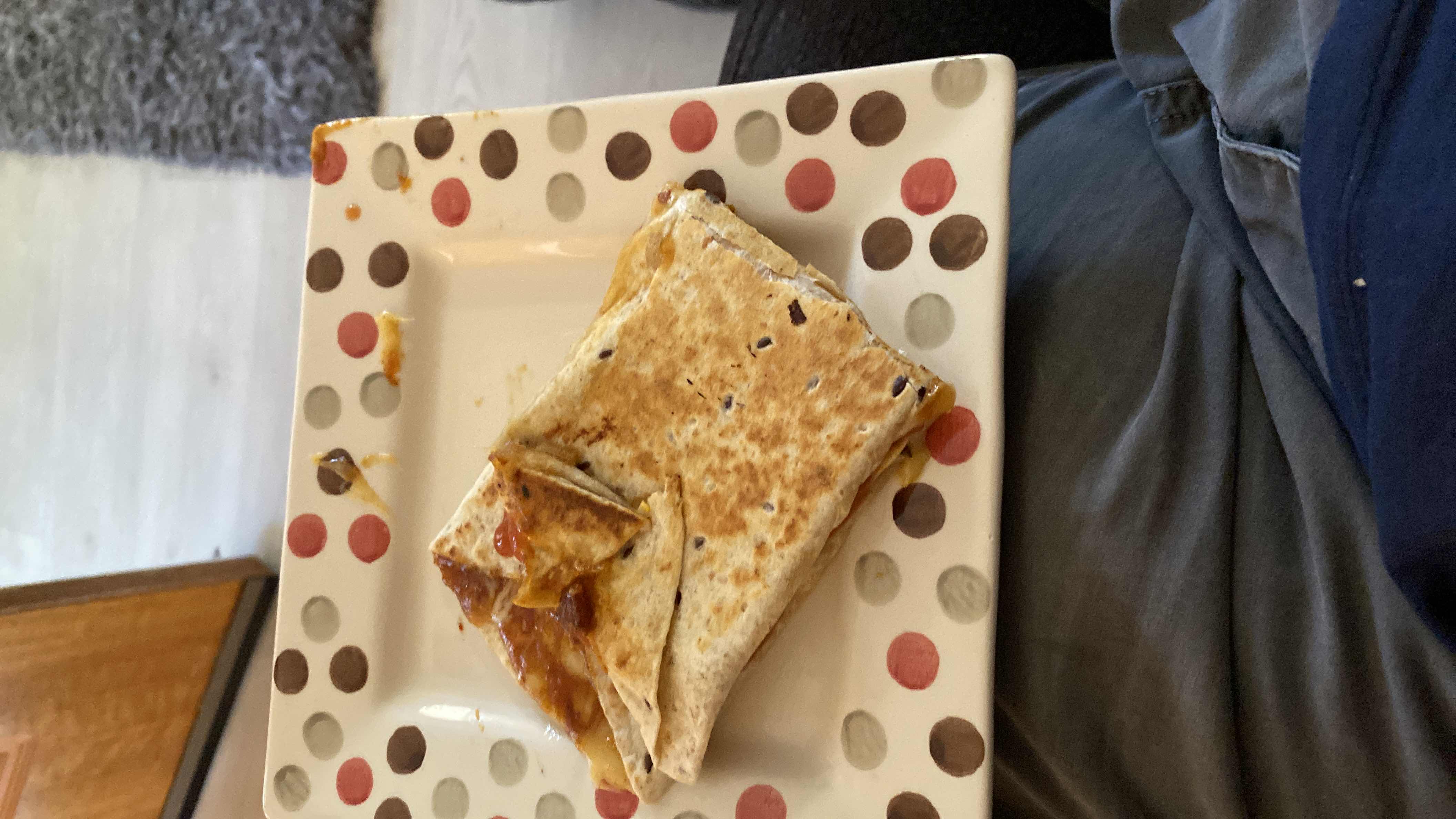 A grilled tortilla wrap filled with cheese, chicken, and salsa, providing a balanced mix of protein, carbs, and fats.