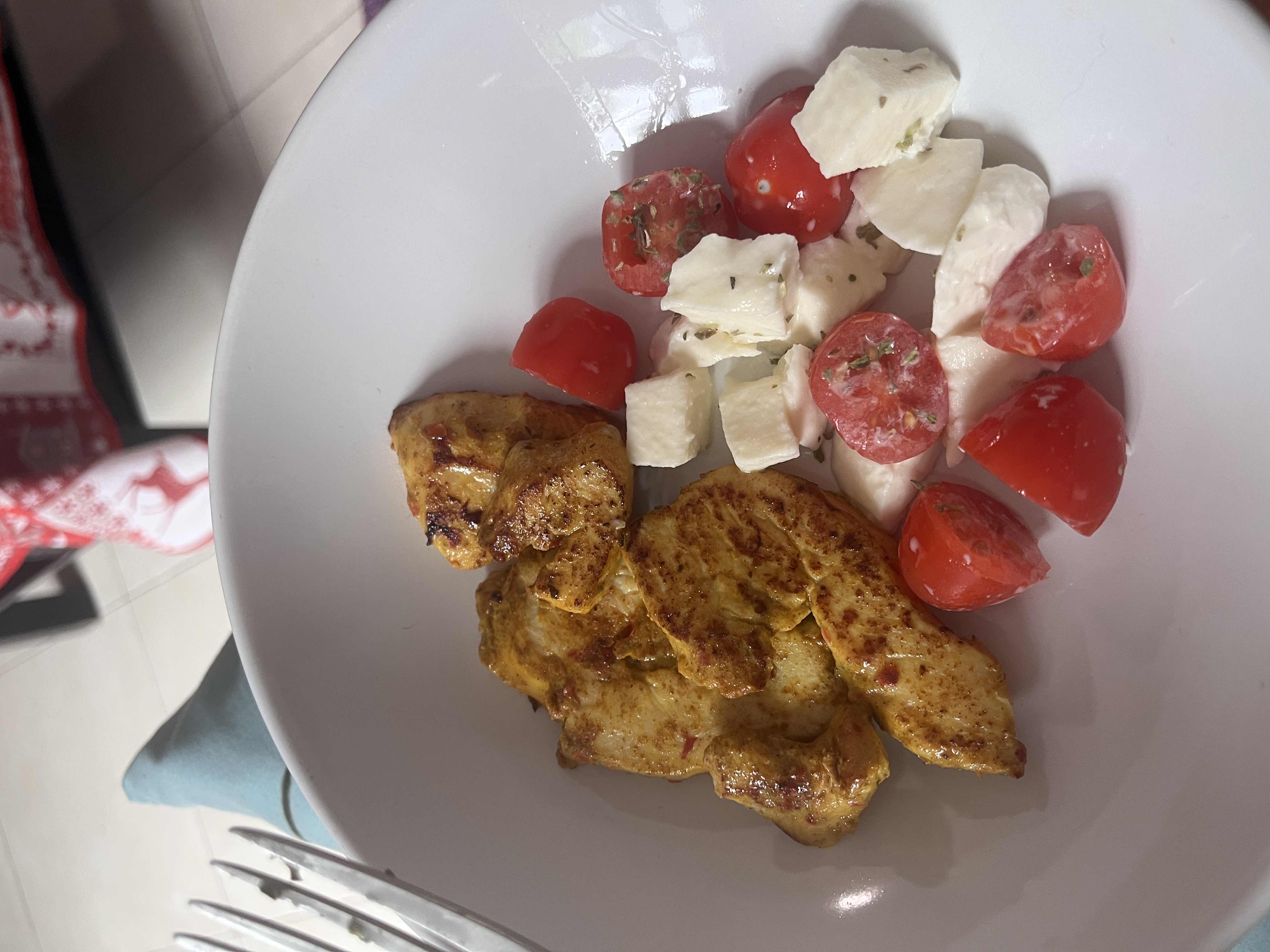 A dish consisting of grilled chicken, cherry tomatoes, and mozzarella cheese, providing a balanced mix of protein, fats, and minimal carbs.