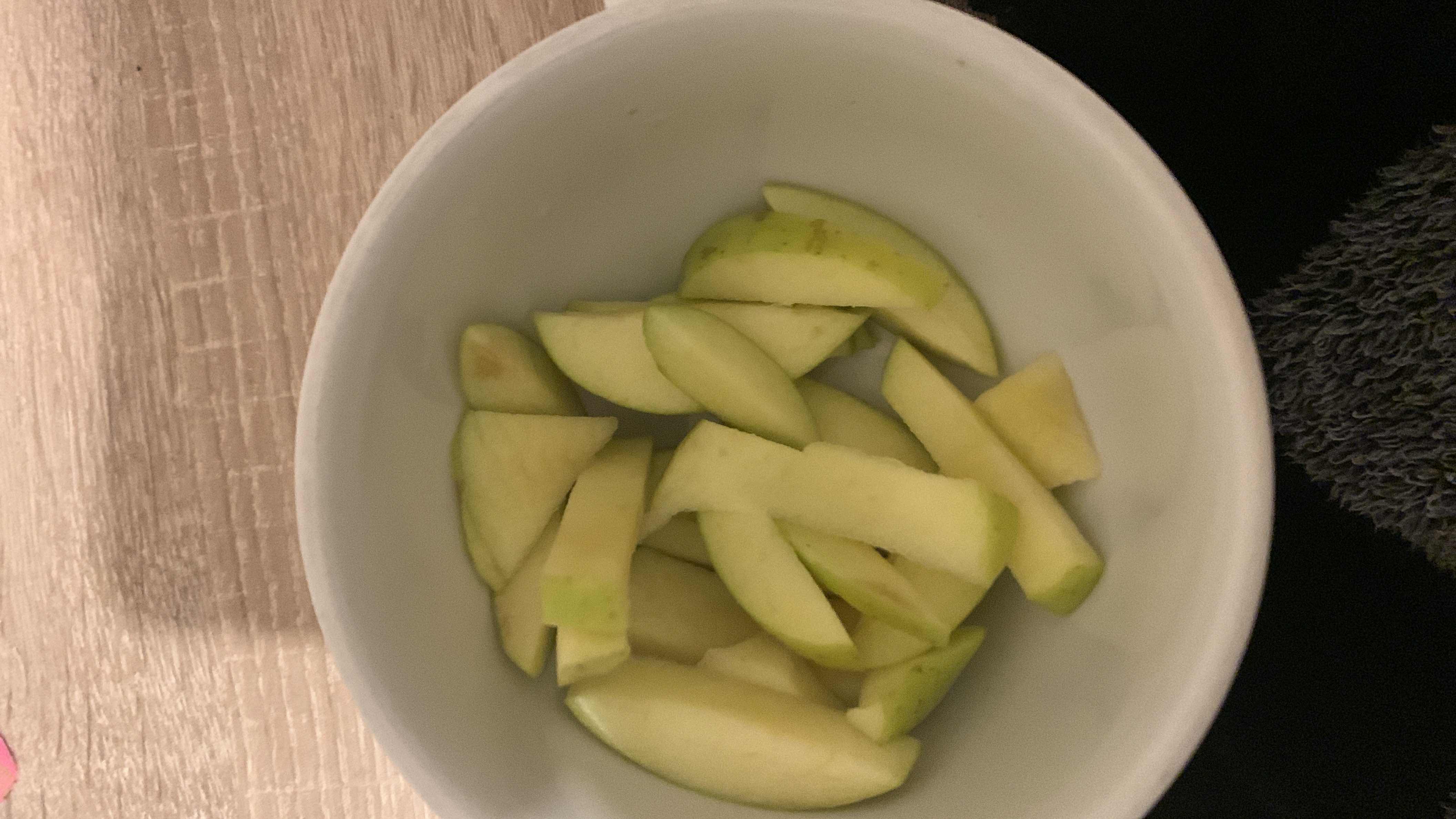 A bowl of sliced green apple, a low-calorie and nutrient-rich snack.