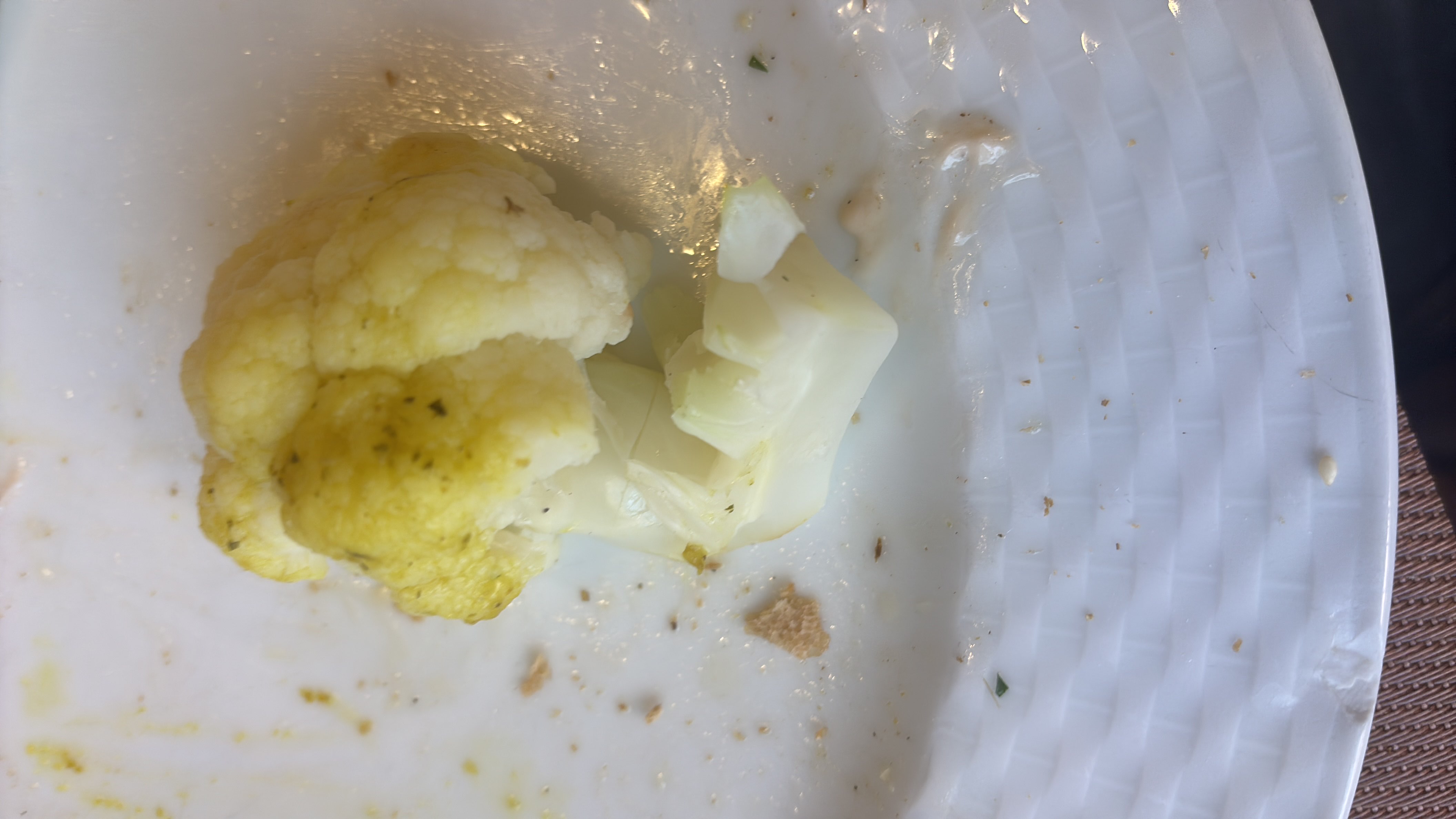 A small portion of cooked cauliflower, lightly seasoned, served on a plate.