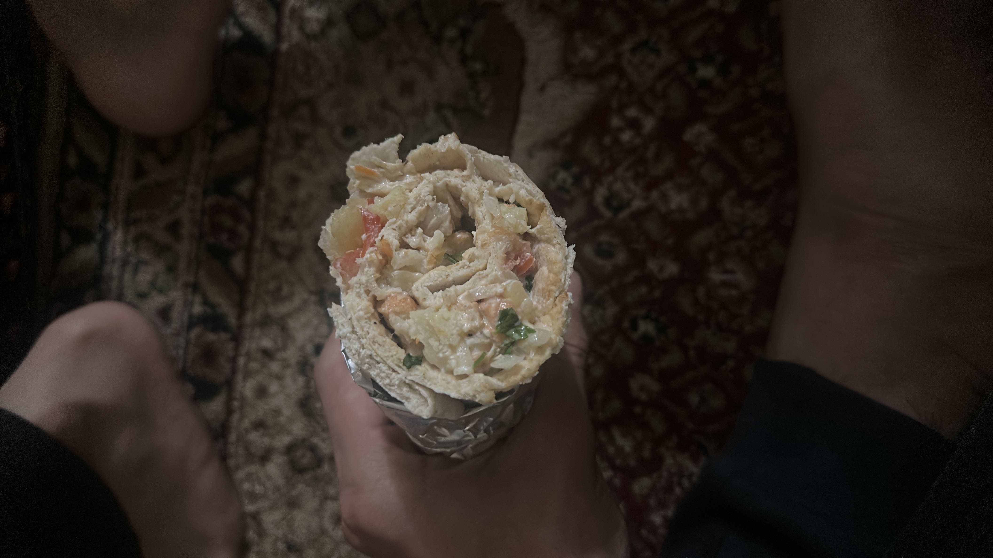 A wrap containing chicken, vegetables, and flatbread, providing a balanced mix of protein, carbs, and fats.