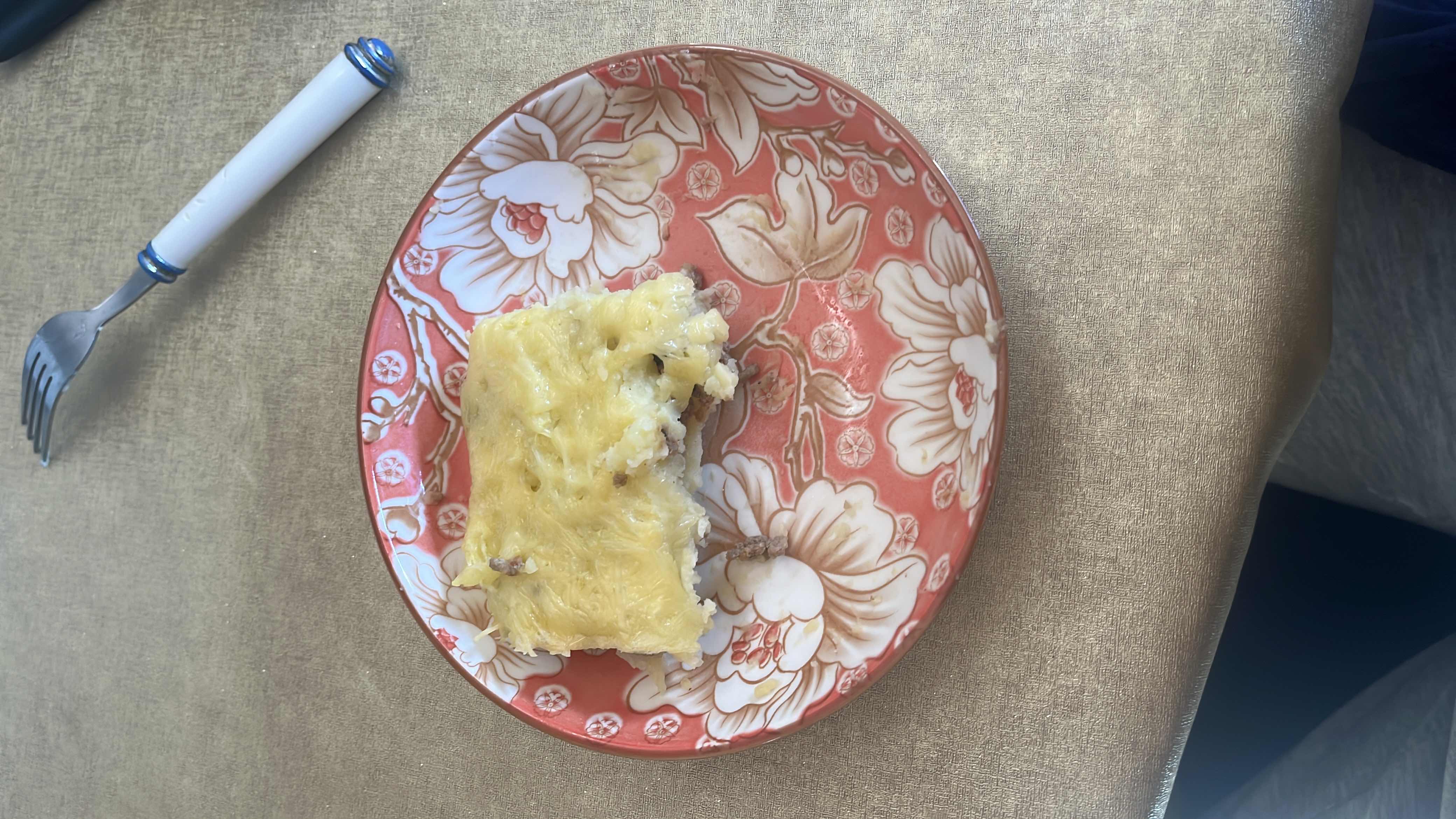 A serving of shepherd's pie with mashed potatoes, ground beef, and cheese.
