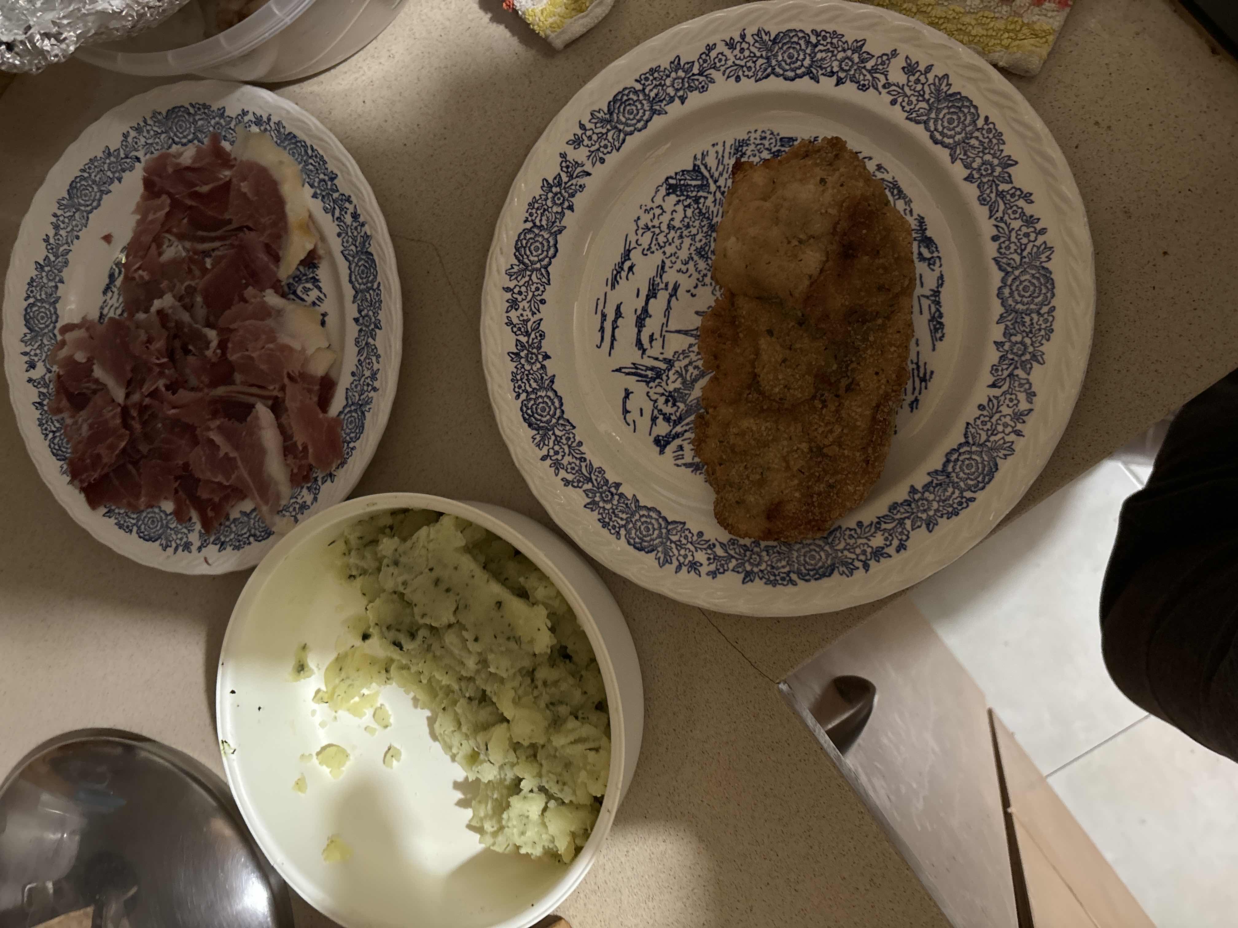 The image shows a meal consisting of mashed potatoes, cured ham, and breaded meat, providing a balanced mix of protein, carbs, and fats.