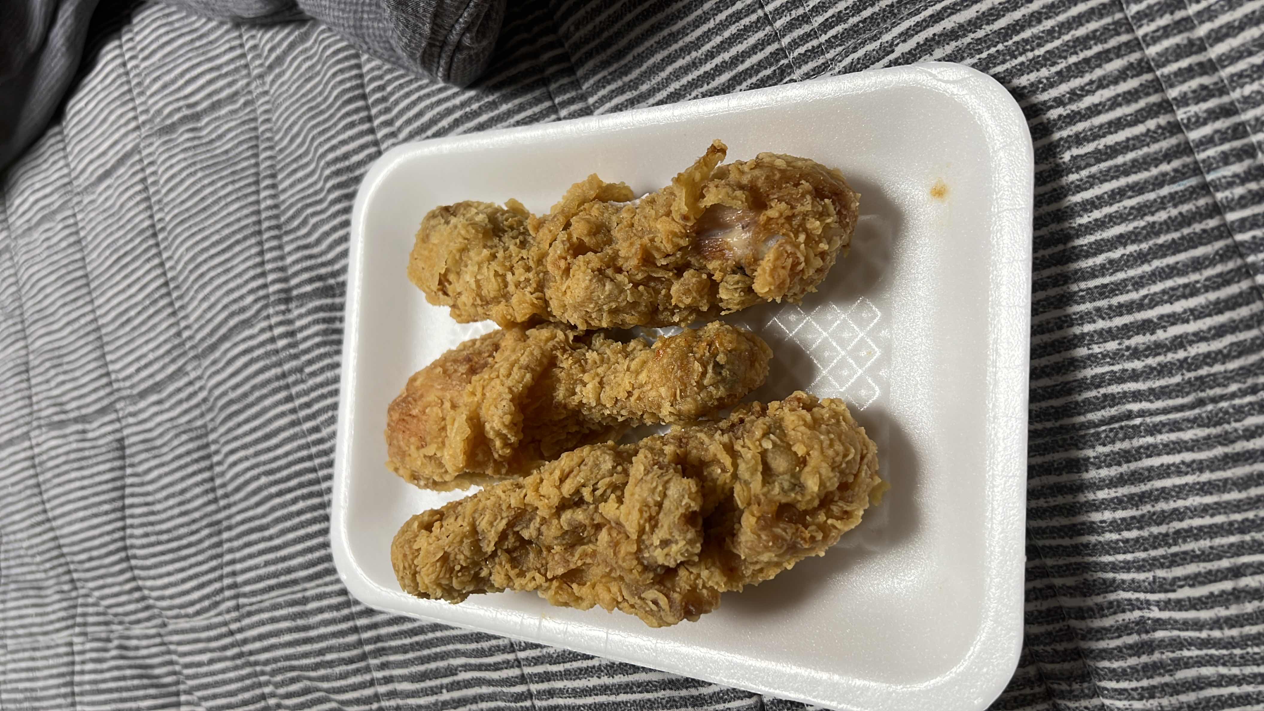 A serving of fried chicken drumsticks, high in calories, protein, and fats, with moderate carbohydrate content.