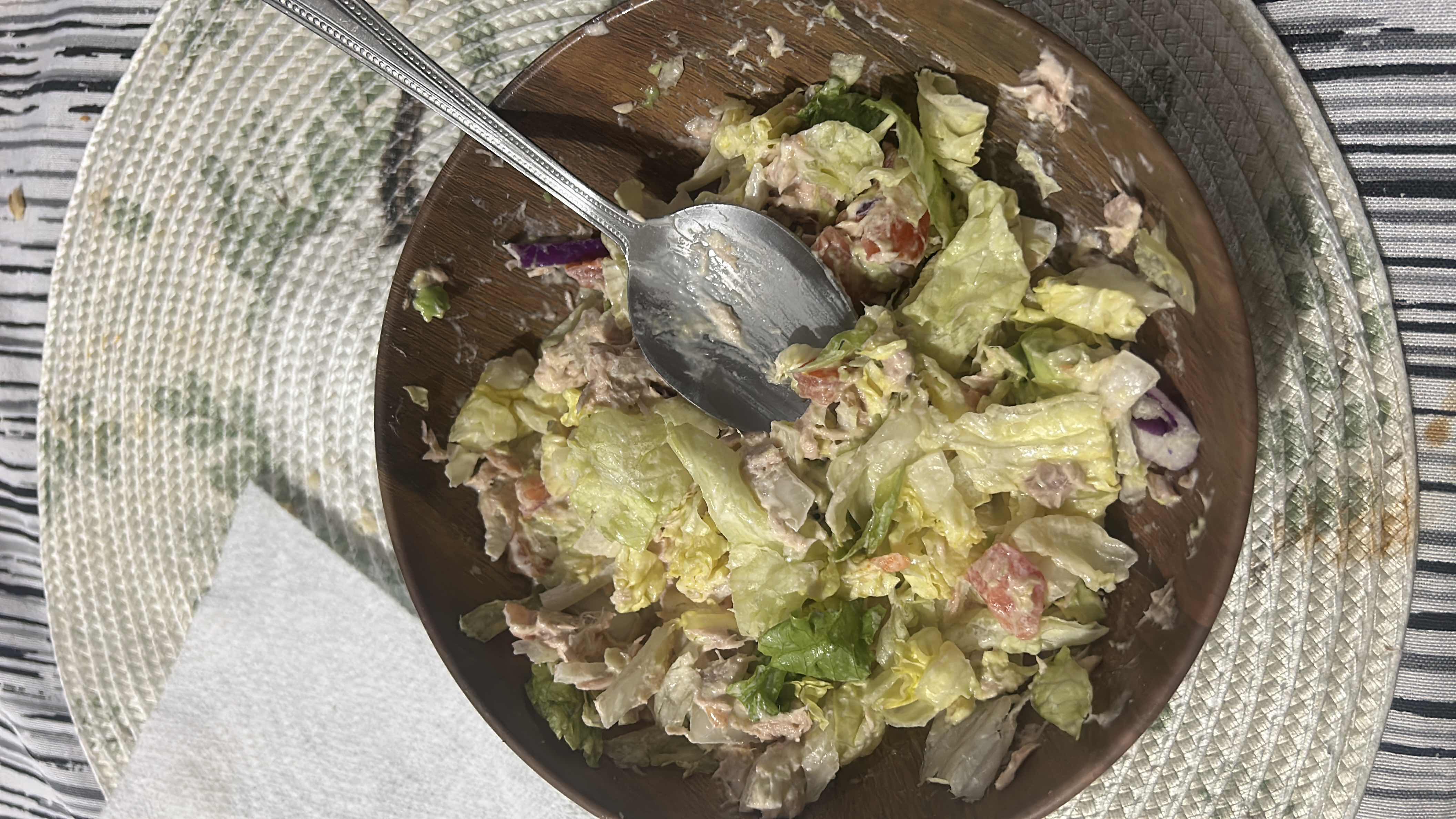 A healthy tuna salad with lettuce, tomato, onion, and mayonnaise, providing a balanced mix of protein, fats, and carbs.