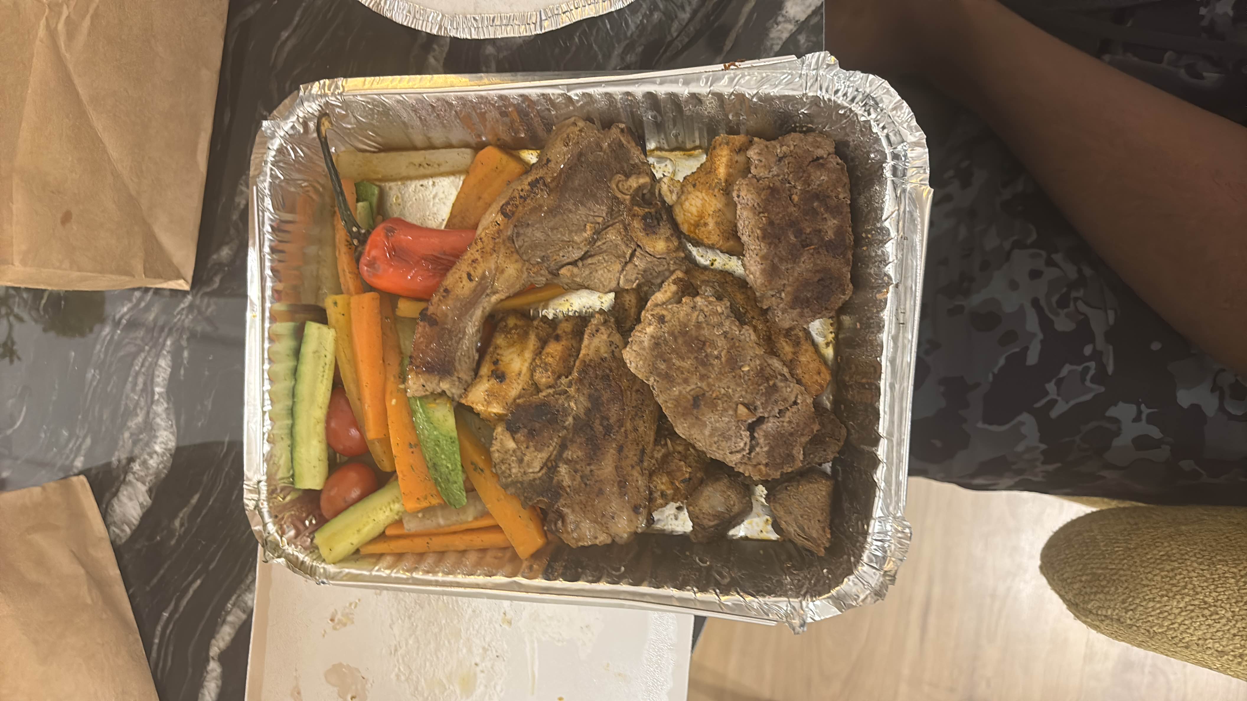 A meal consisting of grilled lamb, grilled chicken, and mixed vegetables, providing a balanced mix of protein, fats, and carbs.