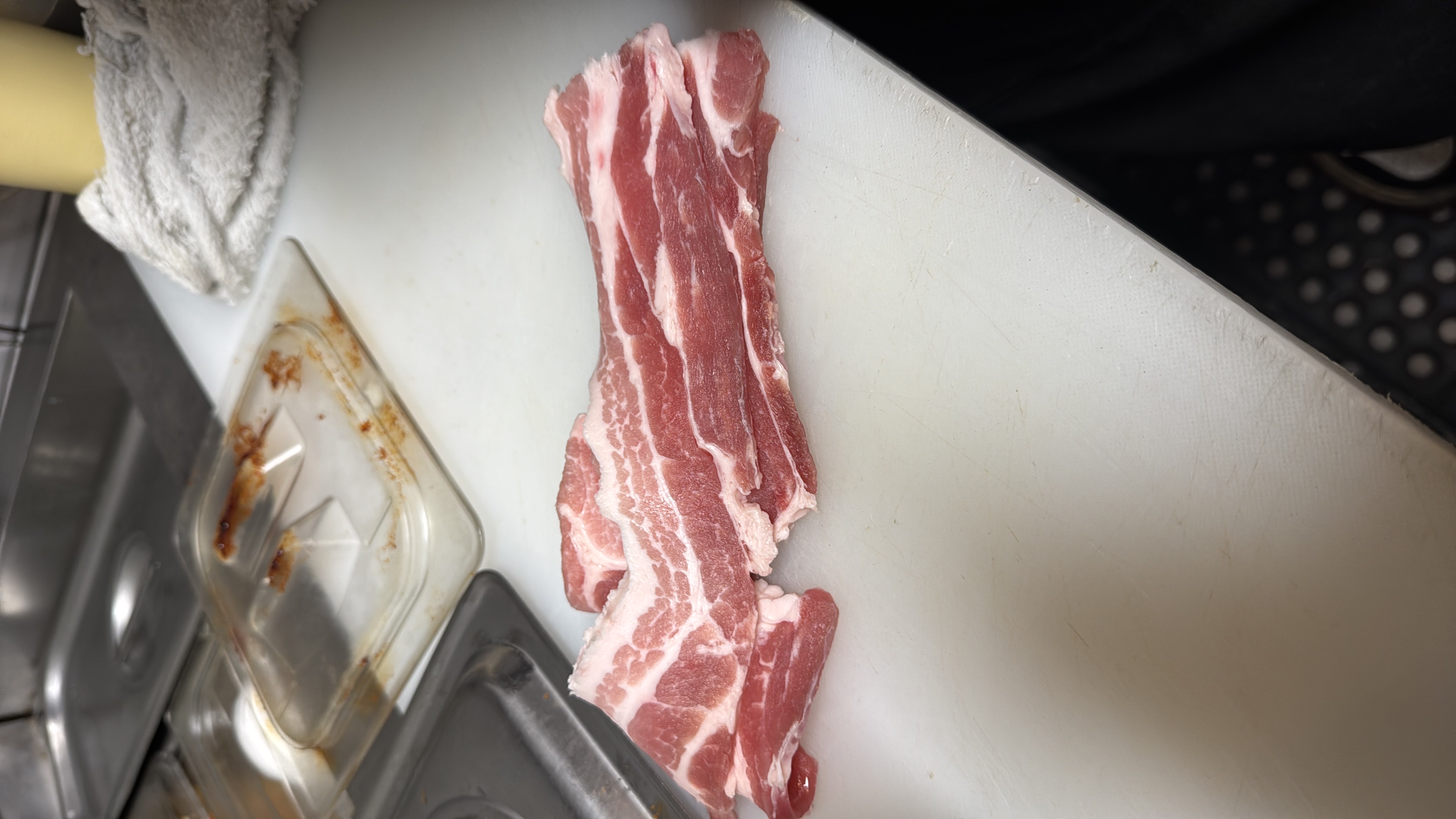 The image shows raw pork belly slices, which are high in fats and protein, commonly used in various dishes.