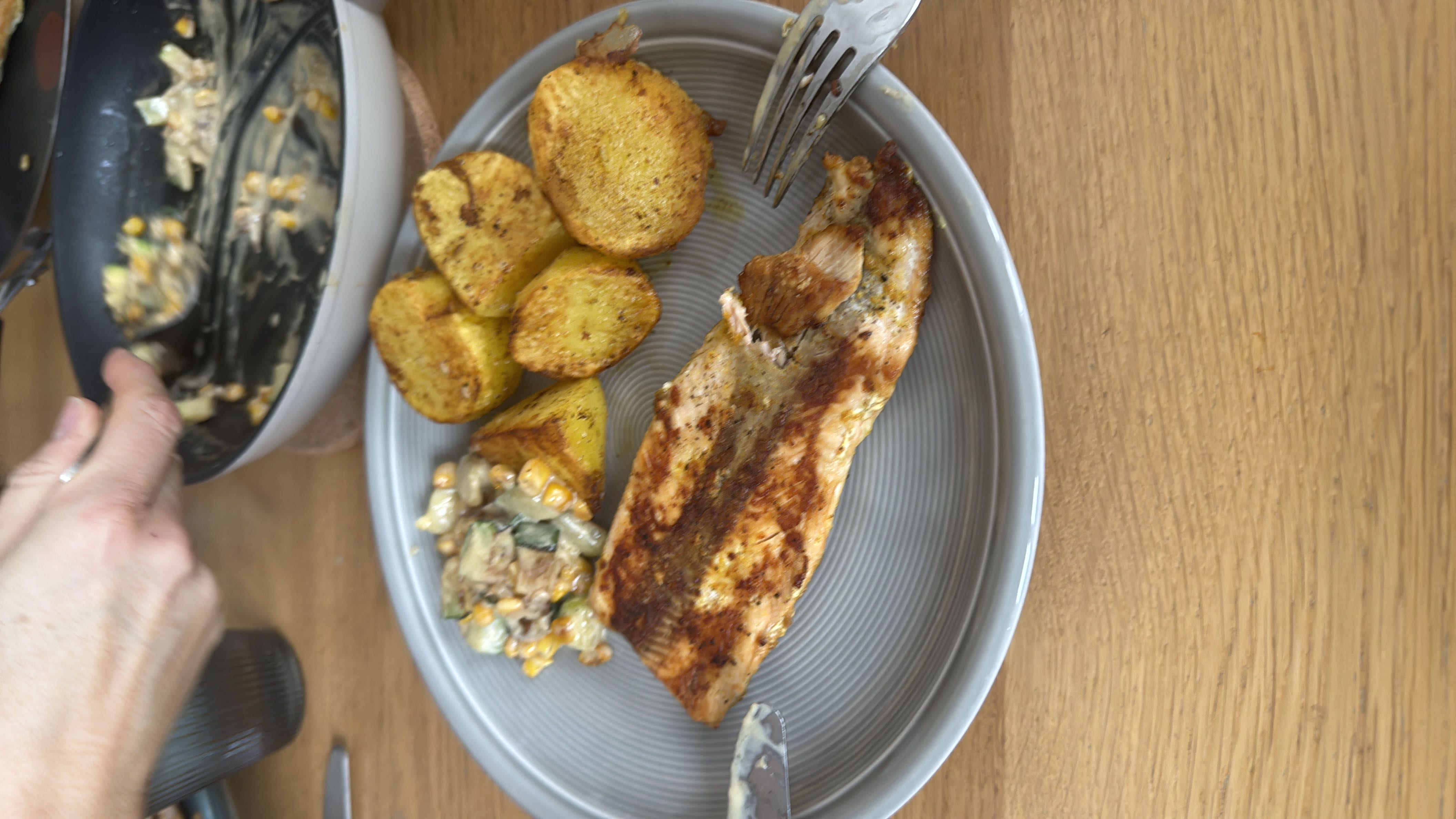 A balanced meal consisting of grilled salmon, roasted potatoes, and a vegetable salad.
