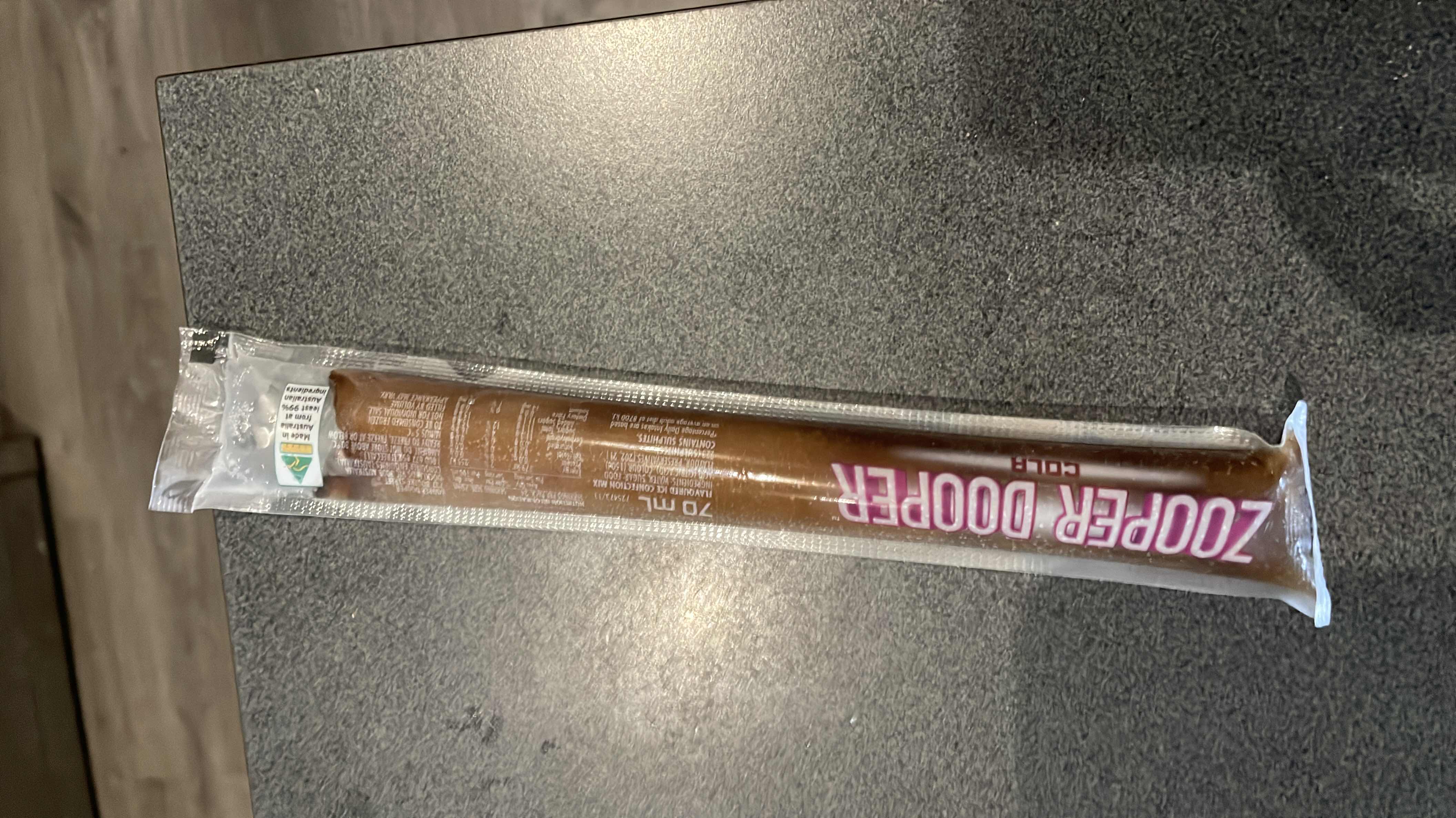 A single-serve frozen cola-flavored treat with low calories, primarily composed of sugar and water.