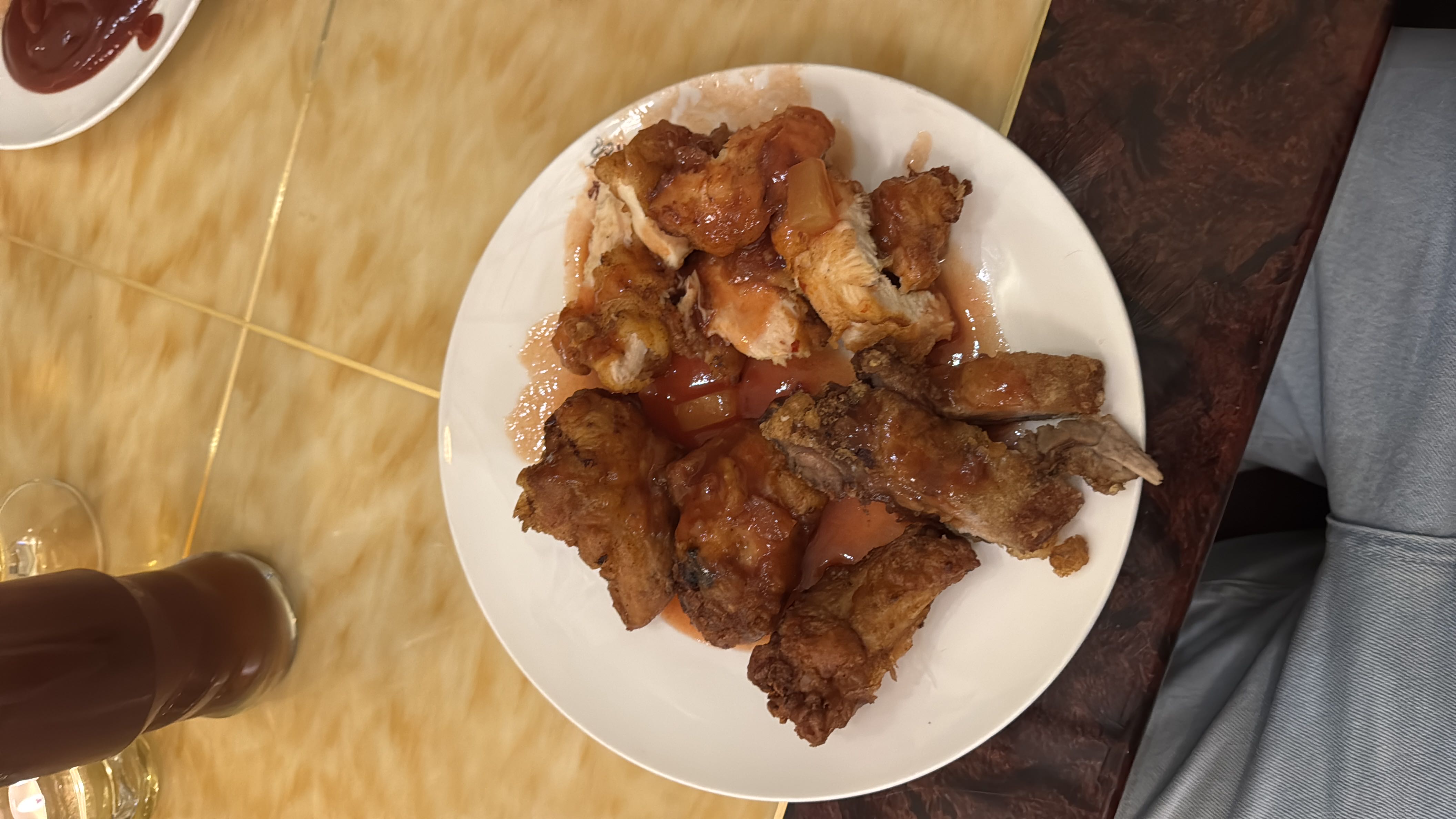 A plate of fried chicken pieces topped with a sweet and tangy sauce, served as a high-calorie meal with moderate protein and high fat content.