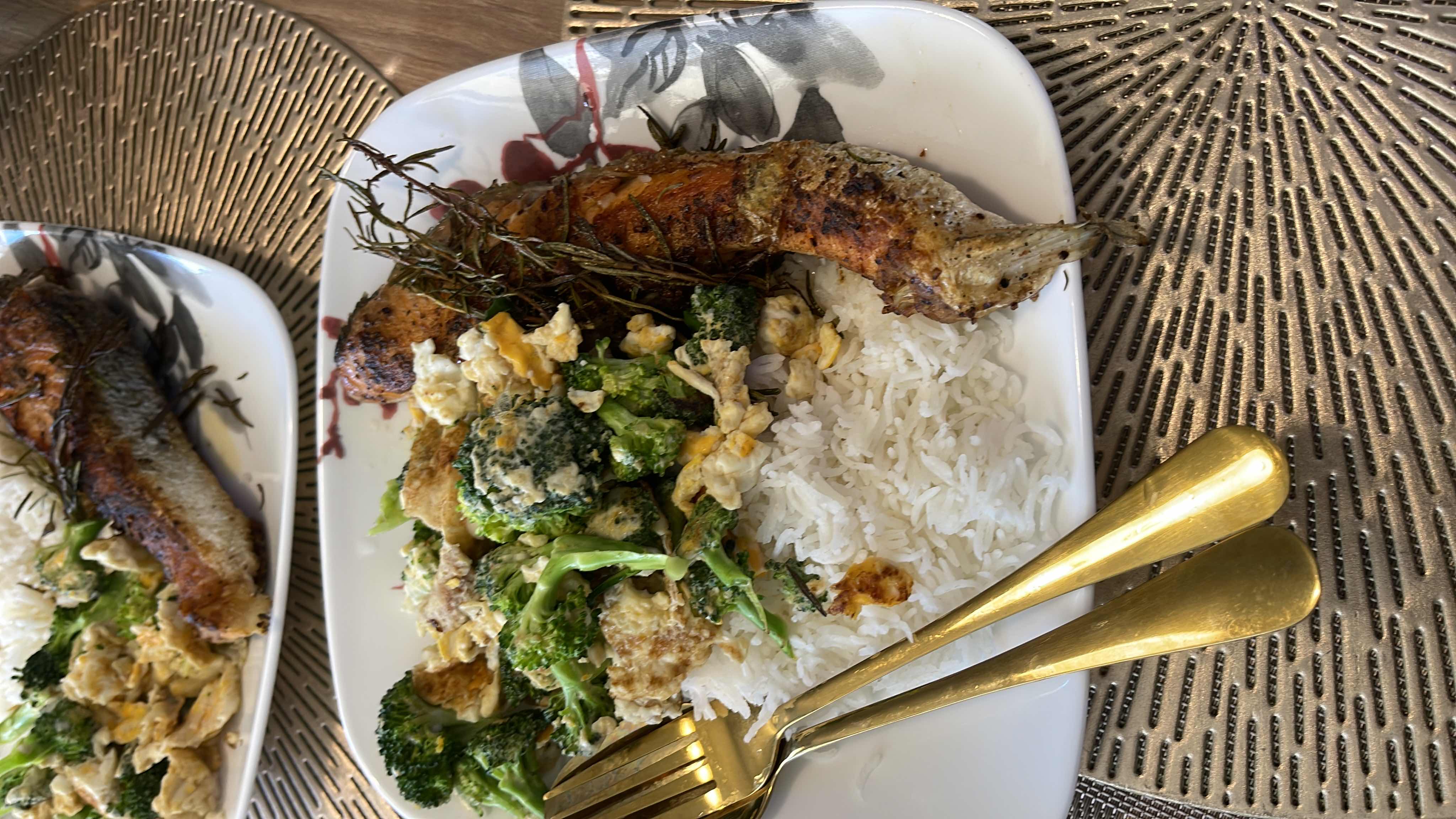 A balanced meal consisting of grilled salmon, steamed broccoli, scrambled eggs, and white rice.